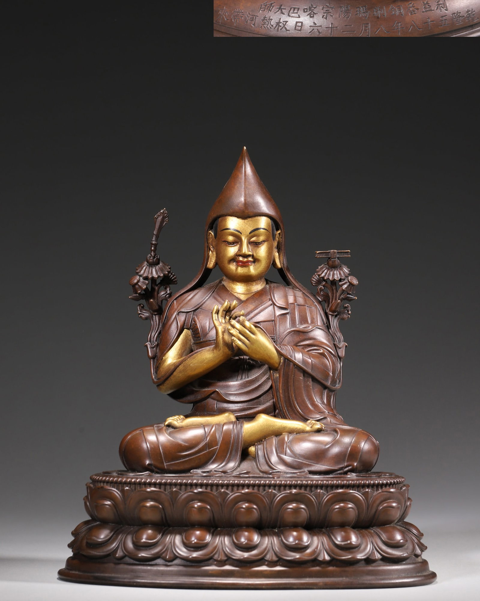 Qing Dynasty, Palace-Made Partially Gilt Bronze Statue of Tsongkhapa, Qianlong Period: A palace-made partially gilt bronze statue of Tsongkhapa from the Qianlong period. The master sits on a lotus throne with a compassionate expression. The statue bears a dated inscription, indicating i