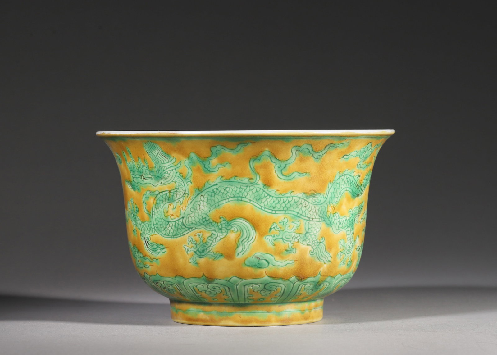 Ming Dynasty, Xuande Period, Yellow-Ground Incised Green Enamel Dragon Bowl: A Ming Xuande bell-shaped bowl with wide flared rim and short foot. The interior is plain white, while the exterior is covered in crackled soft yellow ground glaze with incised twin dragons and clouds