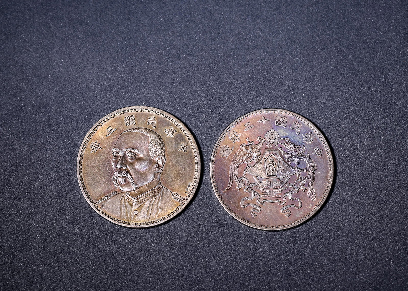 Republic of China (1912-1949 CE), Two Silver One-Dollar Coins: Two silver one-dollar coins. One features portrait, the other dragon-phoenix motif. Reverse bears grain pattern and denomination. Natural toning with fine striking details. Dimensions: Diameter: 3.9cm