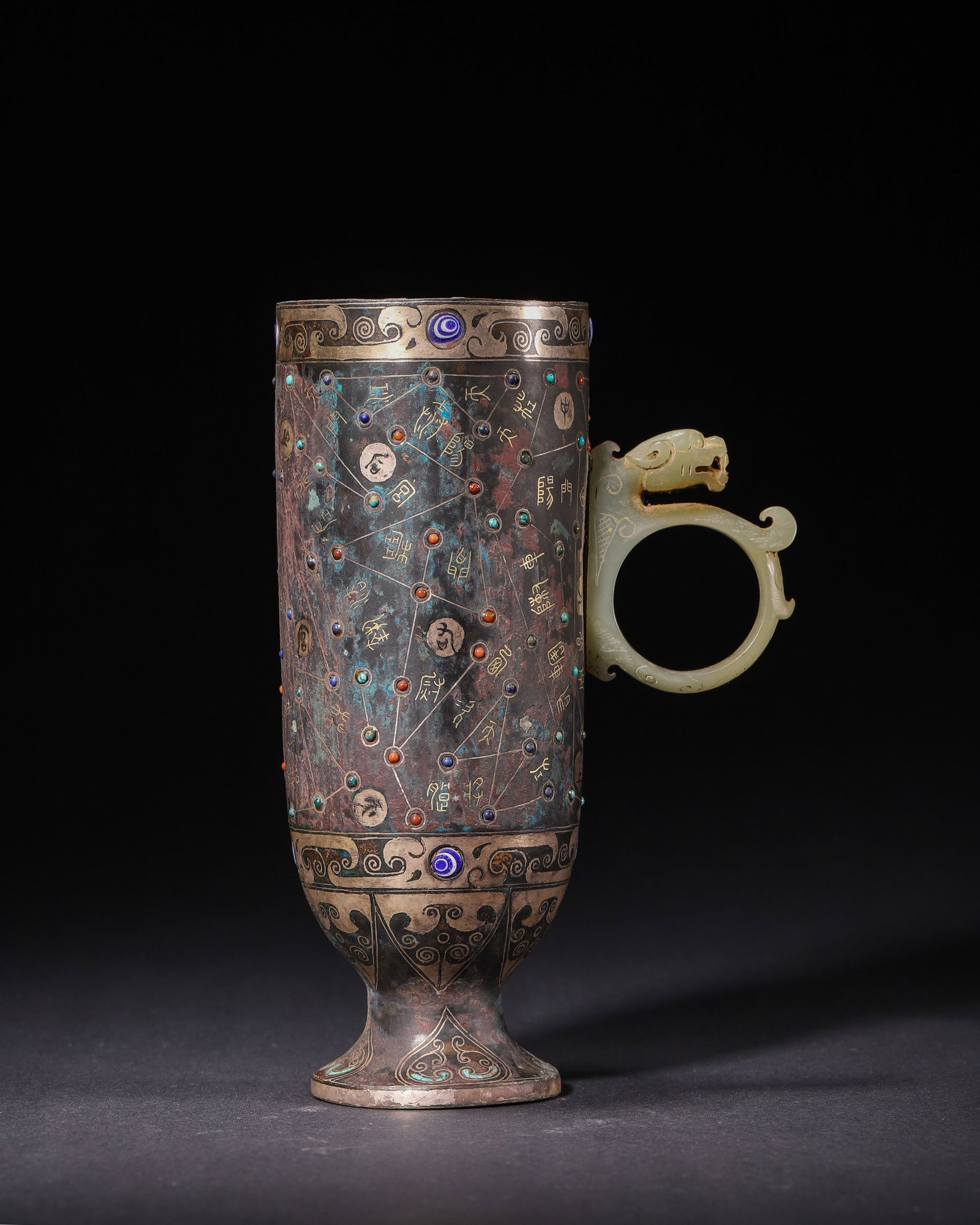 Han Dynasty, Gold and Silver Inlaid Bronze Stem Cup with Jade Dragon Handle: Bronze stem cup inlaid with gold, silver, turquoise, agate and glass, decorated with 28 lunar mansions star map and inscriptions, fitted with a carved jade dragon handle. A fine Han specimen of bronze