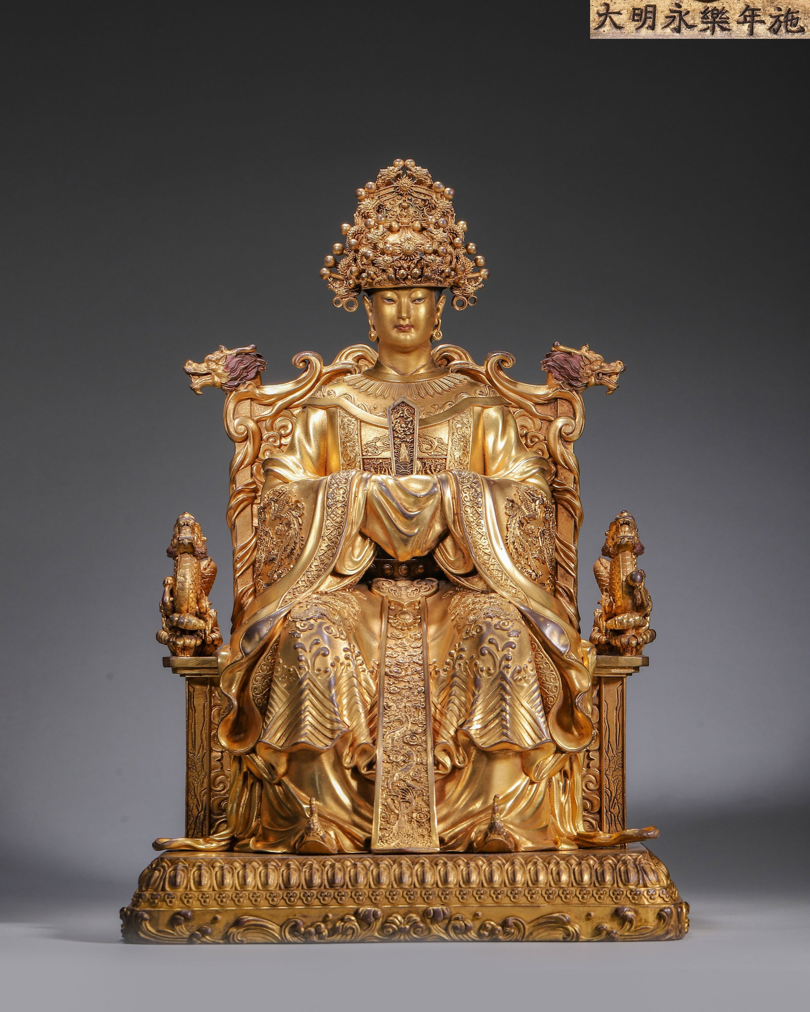 Gilt-Bronze Imperial Palace-Made Sea God, Ming Yongle Period, 1403-1424: Deity seated on dragon-decorated throne,wearing phoenix crown and holding tablet. Robes carved with dragon and phoenix patterns. Inscribed "Bestowed in Yongle Reign",imperial palace-made statue. Dimen