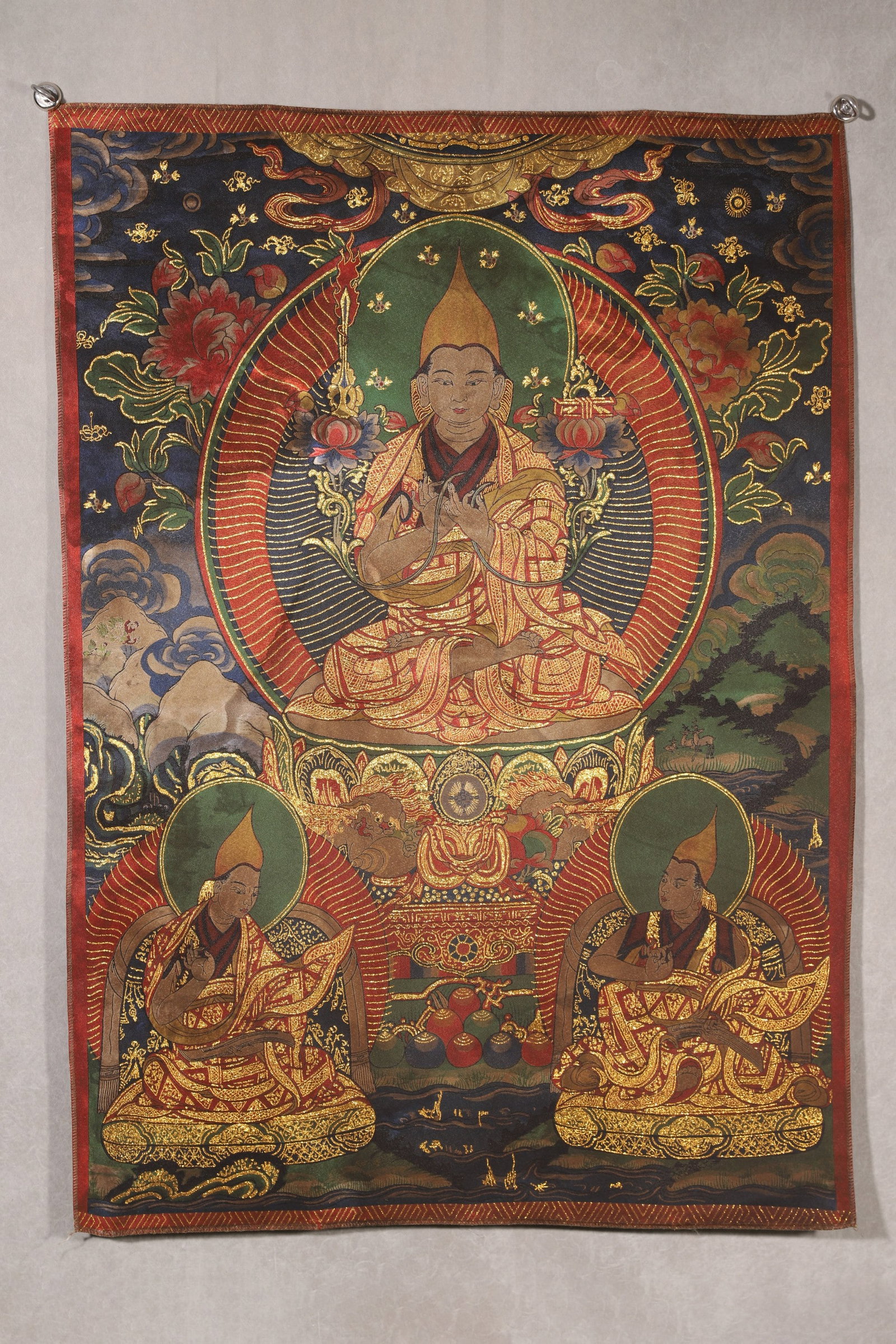 Qing Dynasty, Embroidered Thangka of Tsongkhapa and His Disciples: This Qing Dynasty embroidered thangka is fully stitched with gold threads, depicting Tsongkhapa, the founder of the Gelugpa school, and his two disciples. The central figure sits in full lotus posture