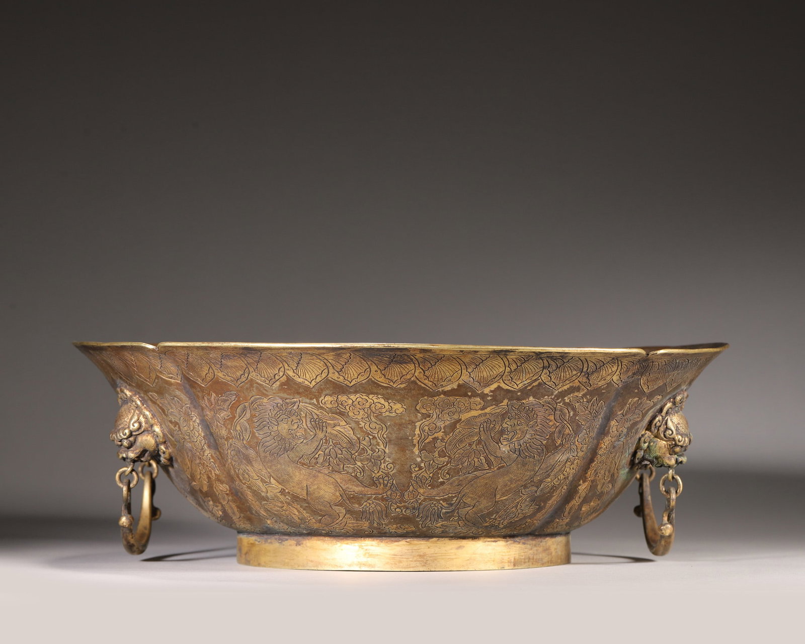 Tang Dynasty, Silver-Gilt Lobed Basin with Carved Double Lions and Beast Handles: This lobed basin is made of silver-gilt, carved with double lions and floral scrolls. The center features embossed double lions playing with a ball, flanked by movable beast-head ring handles. Exquisi