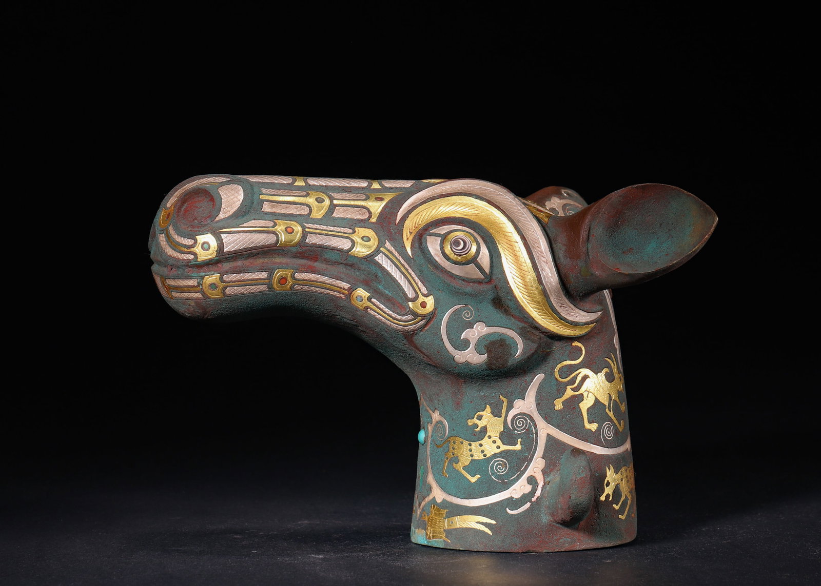 Warring States to Han Dynasty, Gold-Inlaid Bronze Cane Finial with Beast Head: A Warring States to Han Dynasty bronze cane finial with beast head. It is adorned with delicate gold, silver and turquoise inlays. The vivid carving and aged patina reflect exquisite ancient craftsman