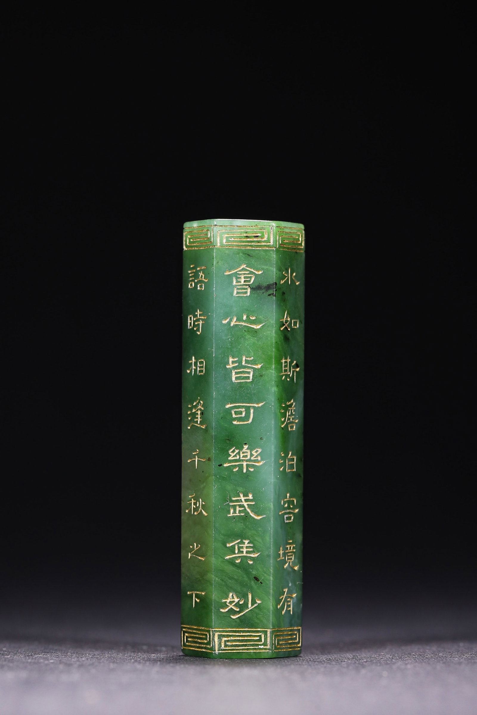 Qing Dynasty, Spinach Green Hetian Jade Hexagonal Lezi with Qianlong Imperial Poem: Hexagonal Hetian spinach green jade lezi with central bore. Incised Qianlong imperial poems filled with gold, fretwork borders at both ends. Neat carving and natural patina. Dimensions: Diameter: 1.6c