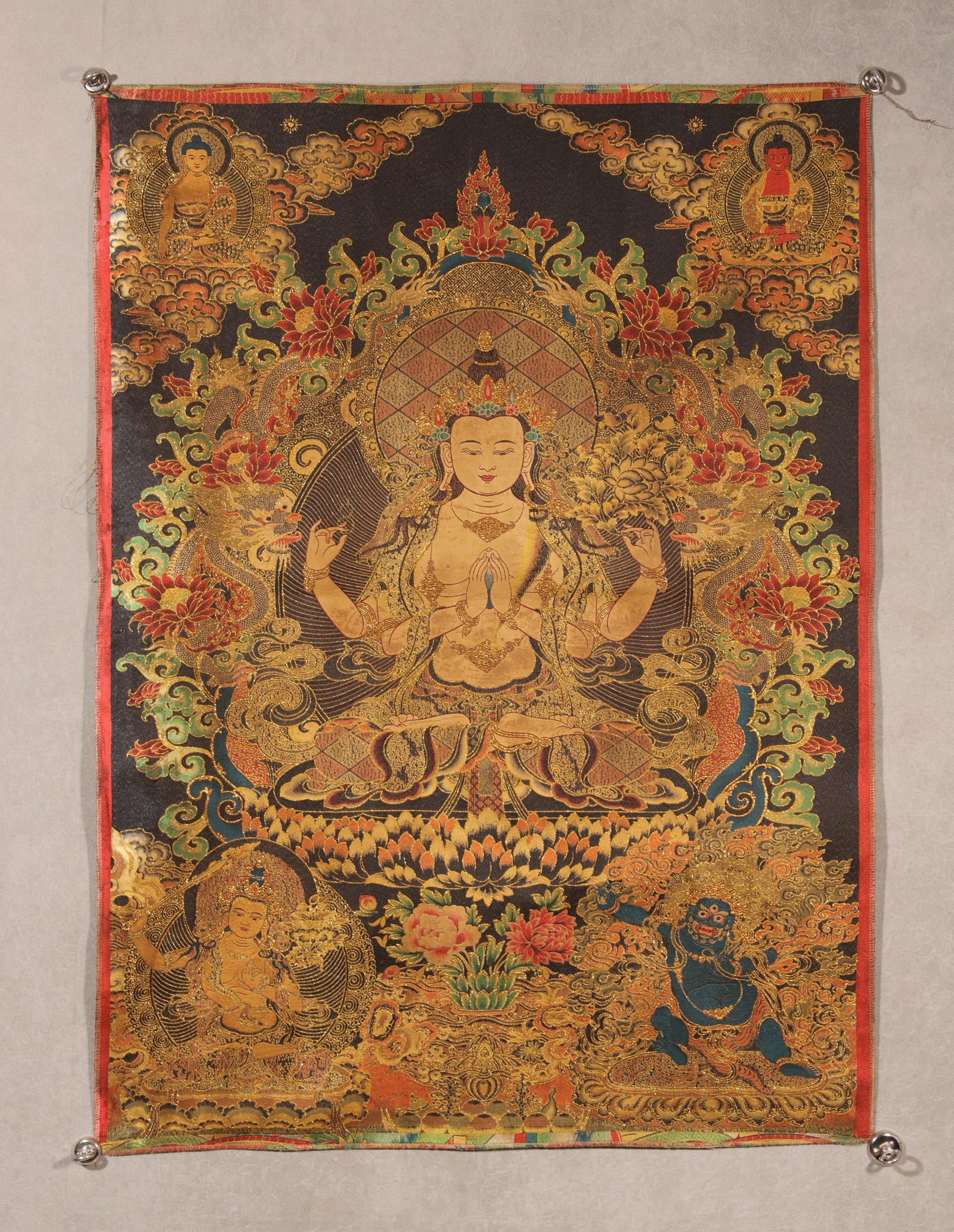 Qing Dynasty, Embroidered Black-and-Gold Thangka of Four-Armed Avalokiteshvara: A Qing Dynasty embroidered black-and-gold thangka depicting the Four-Armed Avalokiteshvara seated on a lotus throne. Meticulously crafted with fine embroidery and gold threads, featuring auspicious dr