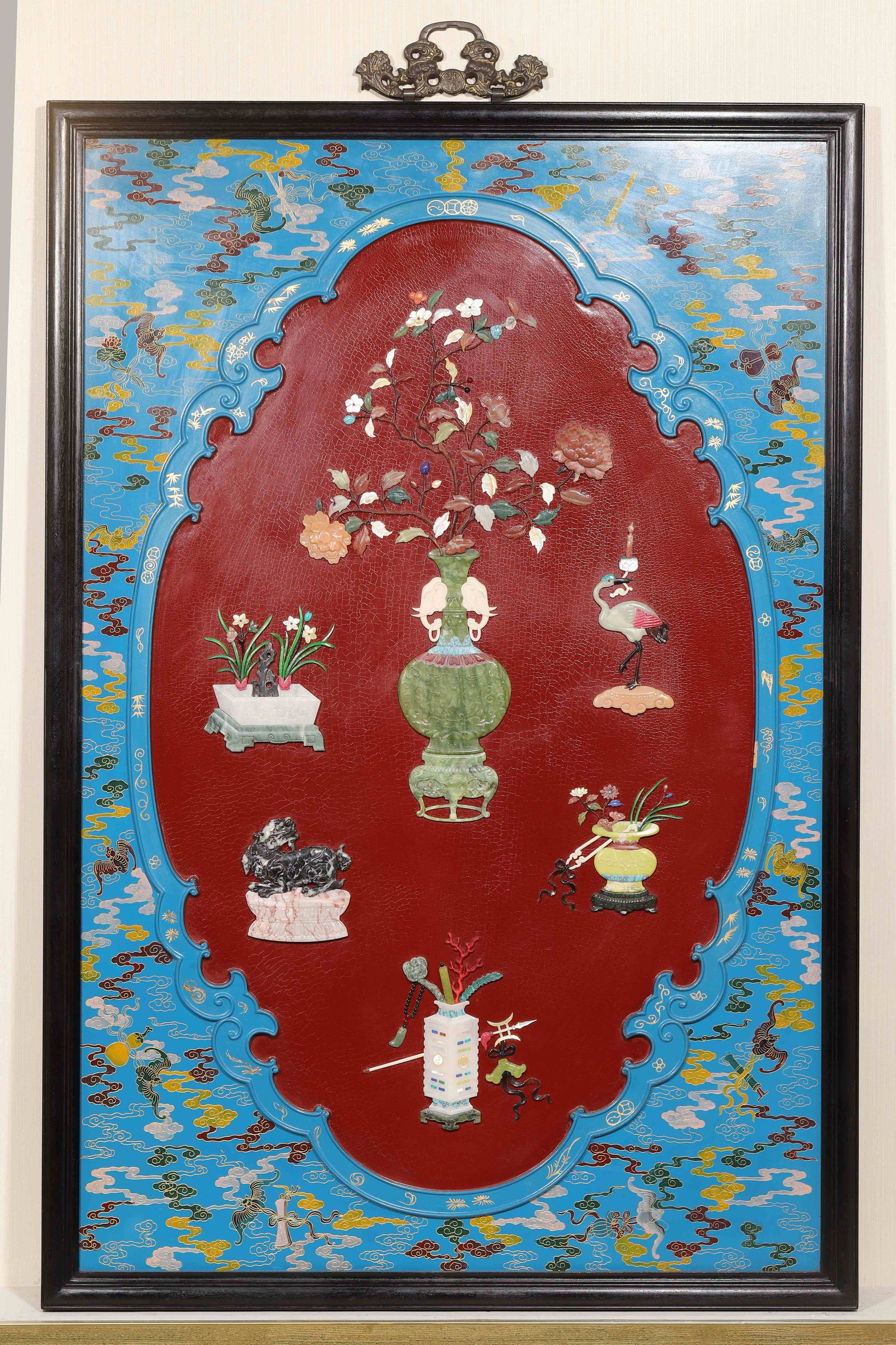 Gilt-Decorated Blue Lacquer Hanging Panel with Precious-Inlaid Antiquities, Qing Dynasty (1644-1912): Gilt cloud and treasure motifs on blue lacquer, red lacquer cartouche, zitan frame with gilt openwork hanger. Precious inlay of vases, crane and auspicious beasts, full-composition auspicious wall pan