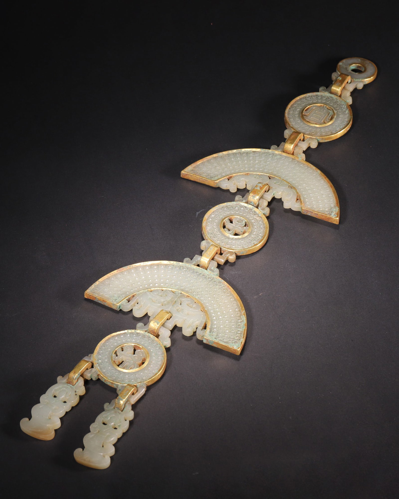 Han Dynasty, Hetian White Jade Copper-Clad Dragon-Form Pendant: A Han Dynasty Hetian white jade pendant with full copper cladding. The jade is fine and smooth with aged patina. Intricate openwork and relief carvings of grain and dragon patterns. Connected by movab