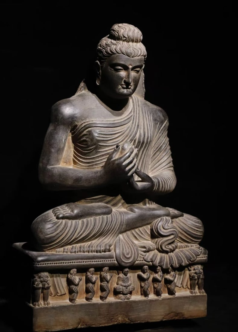 3rd Century Gandhara, Stone Buddha Statue: Seated Shakyamuni Buddha carved from schist, Gandhara art of the 2nd-3rd century Kushan Dynasty, a Hellenistic Buddhist stone sculpture. The Buddha has spiral ushnisha on the crown, a serene face with