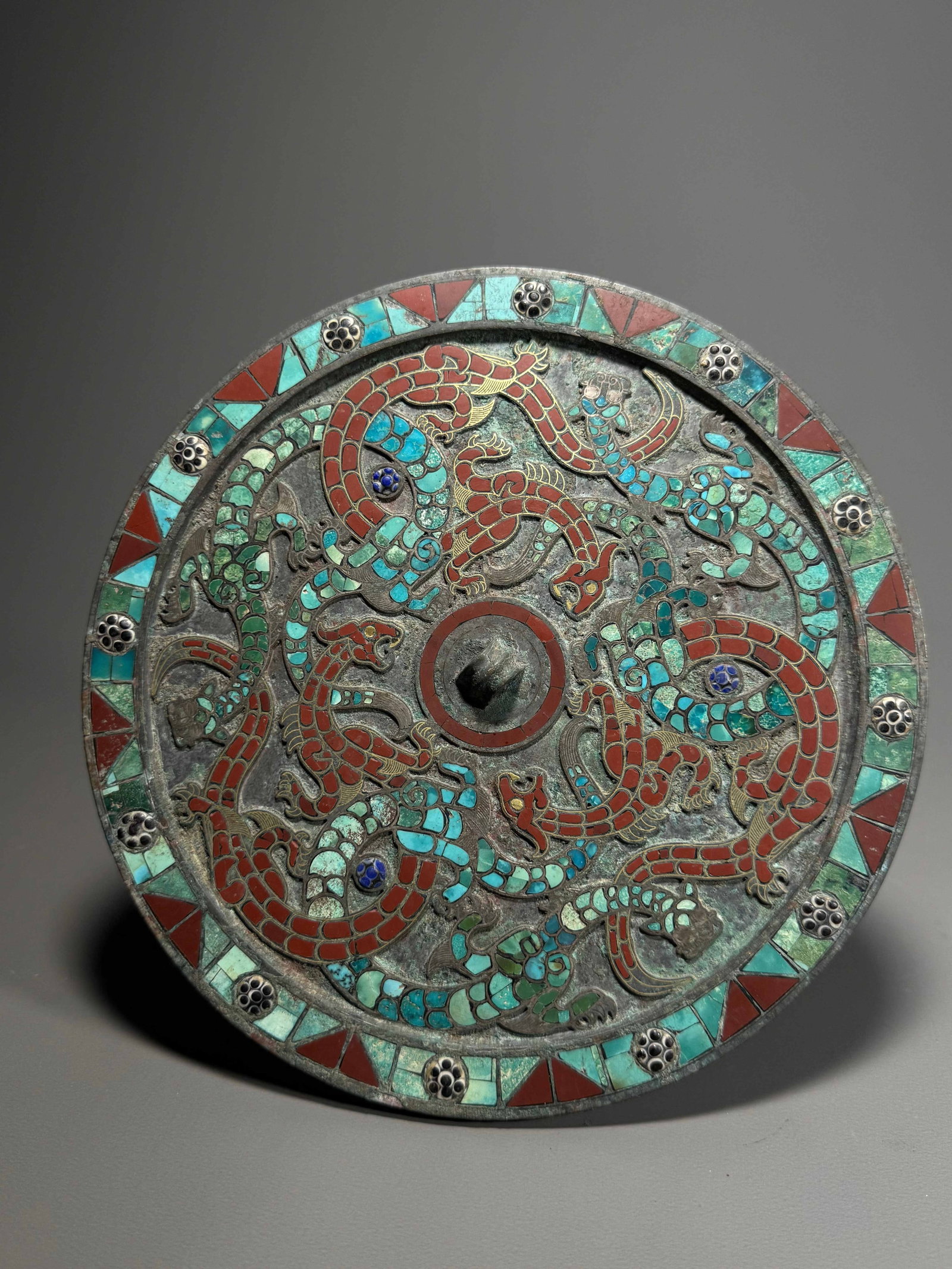 Han Dynasty, Gold and Gem-Inlaid Bronze Dragon Mirror: Han Dynasty, Bronze Circular Mirror with Gold Inlay and Multi-Gem Inlaid Intertwined-Dragon Decoration.Central knob set at the center of mirror back. Coiling dragons are outlined by gold wire inlay. D