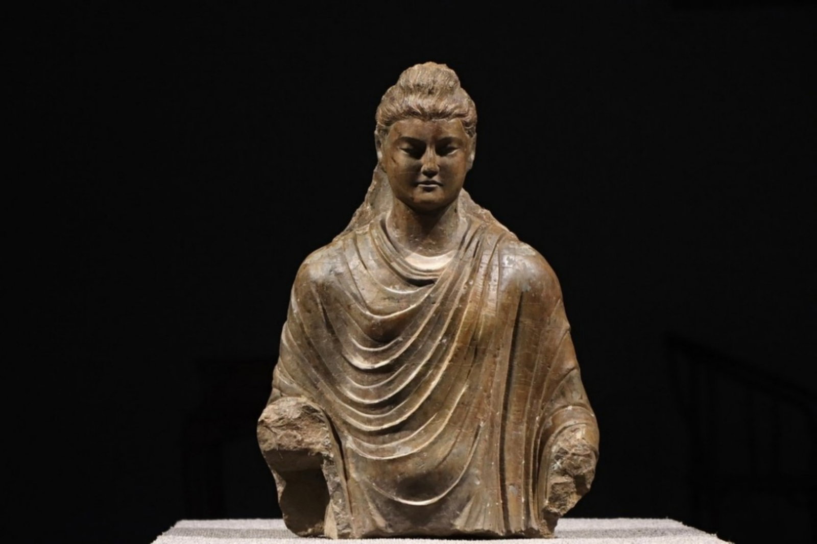 4th Century, Fragmentary Gandhara Bluestone Buddha Bust: 4th Century, Fragmentary Gandhara Bluestone Buddha Bust, offered in sound overall condition. Dimensions: Height: 50cm (19.69in), Width: 37cm (14.57in) Item description ? The East is Red Auctions