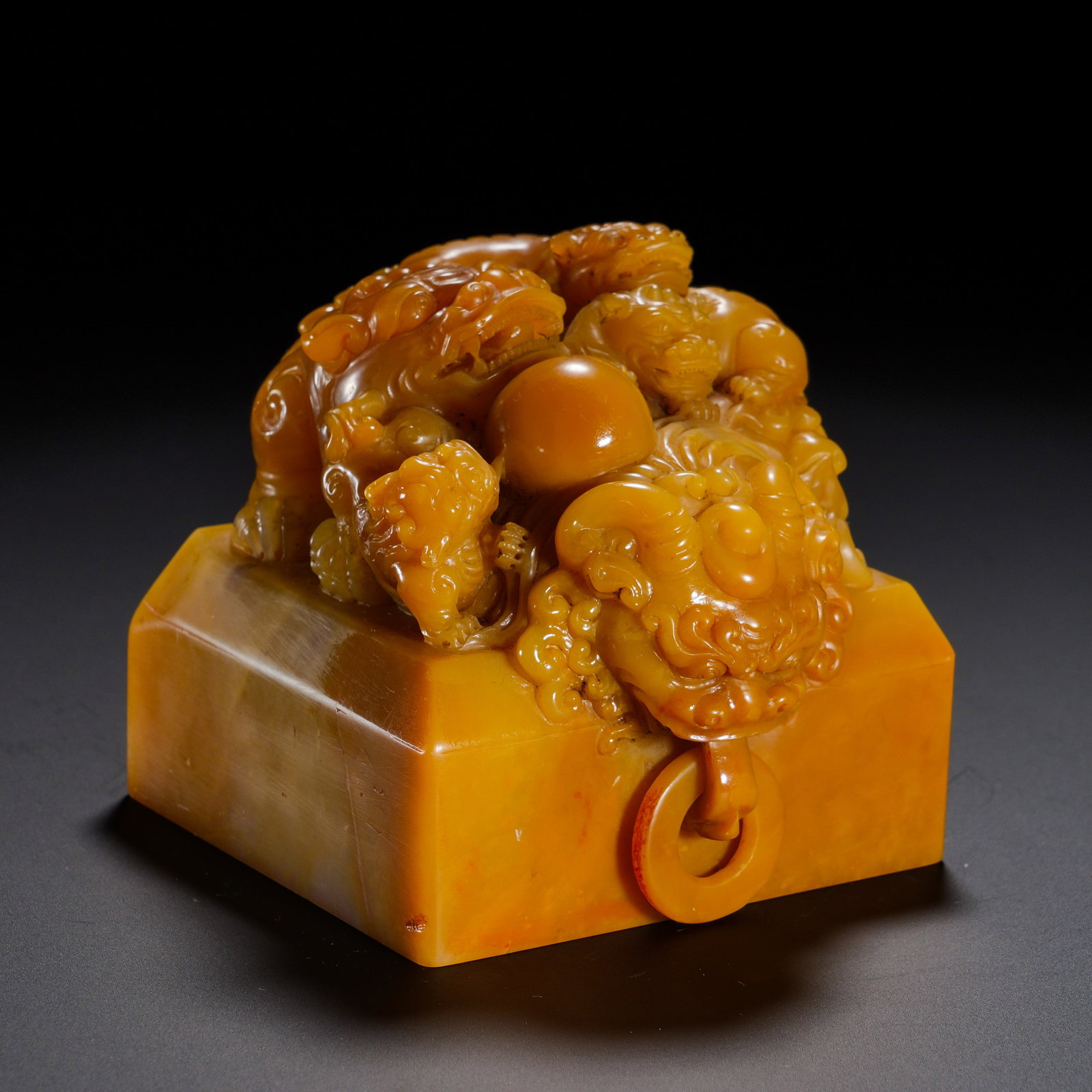 Qing Dynasty, Shou Shan Tian Huangqun Lion Playing with a Pearl Living Ring Button Square Imperial: A monumental square imperial seal of Qing dynasty carved from substantial Shoushan Tianhuang stone. The dense oily stone possesses warm honey-yellow hue and deep antique patina. The knob is high-relie