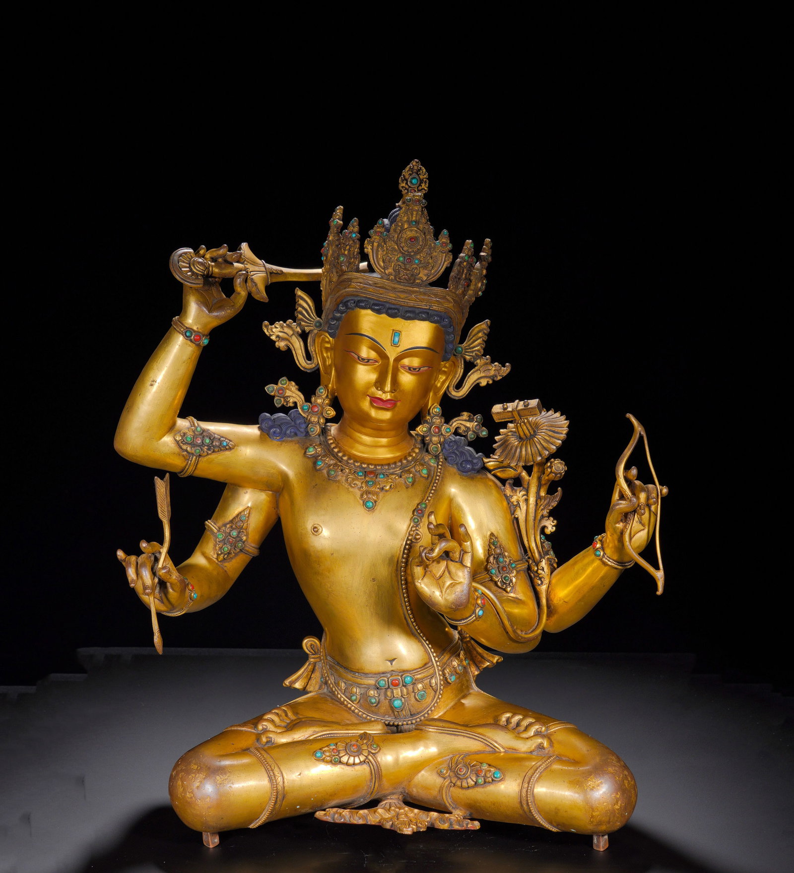 18th-Century Gilded, Bronze Seated Statue of Manjusri Bodhisattva: Gilt Bronze Seated Six-Armed ManjushriThis gilt bronze six-armed Manjushri sits in padmasana. He possesses a full, serene face with gently lowered eyes, conveying pure wisdom. Wearing a gem-inlaid fiv