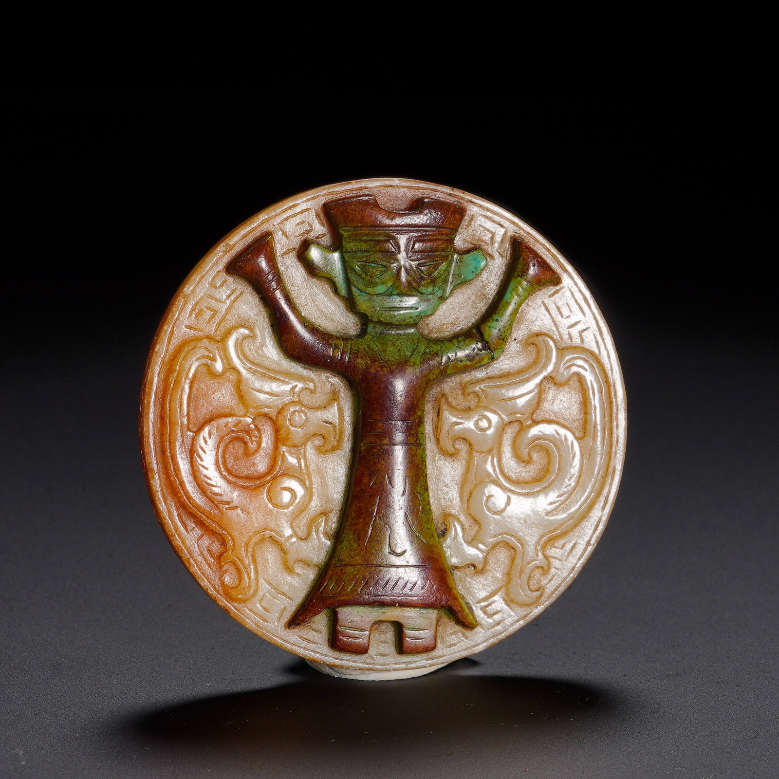 Shang and Zhou Dynasties, Hetian Jade Pendant with Turquoise Inlaid Divine Figure and Double Dragon: Carved from Hetian jade, this round pendant bears antique mellow texture with reddish-yellow ancient patina and partial turquoise inlay, presenting gorgeous archaic color and thick aged patina. The ci