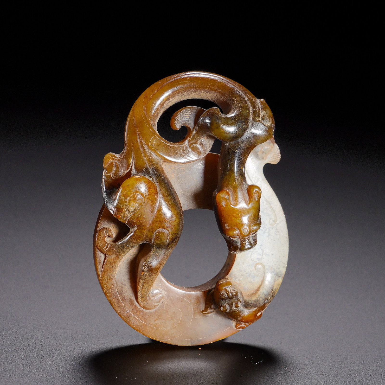 Han Dynasty, Hetian Jade High Relief Chidragon Pattern Jade Ring: Carved from Hetian jade, this ring is heavily patinated with intermingled brown-yellow antiquity stains and partial whitish texture, covered by ancient mellow patina. Adopting high-relief and openwork