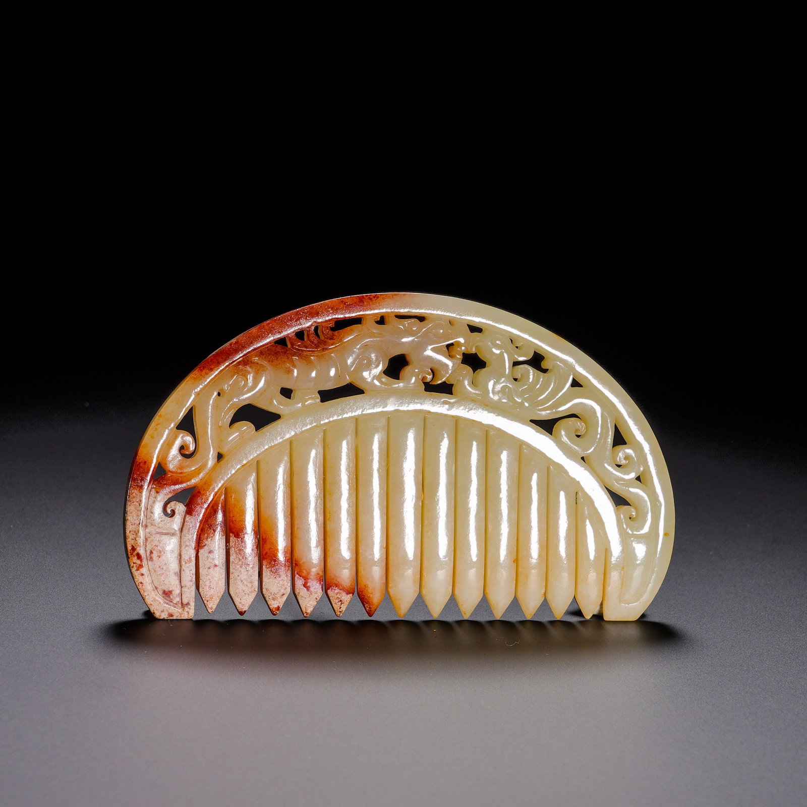 Han Dynasty, Hetian Jade Comb with Pierced Dragon and Phoenix Patterns: Carved from Hetian jade, this comb features mild texture with rich reddish-brown ancient patina along edges and glossy aged patina. The semi-arc-shaped comb has neatly arranged smoothly-polished teeth