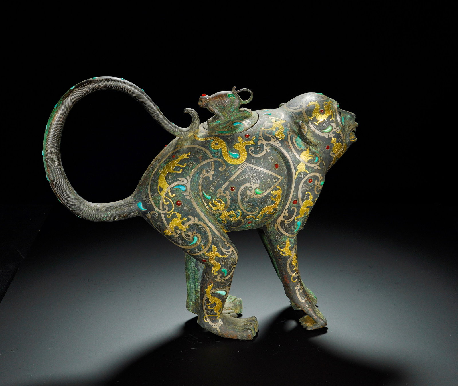 Han Dynasty, Bronze Inlaid with Gold and Silver Inlaid in the Shape of a Monkey: This Han-dynasty bronze ritual wine zun is modeled as a striding spiritual monkey, with raised open-mouthed head and elegantly curled-up long tail, exhibiting vigorous and vivid posture. An opening is