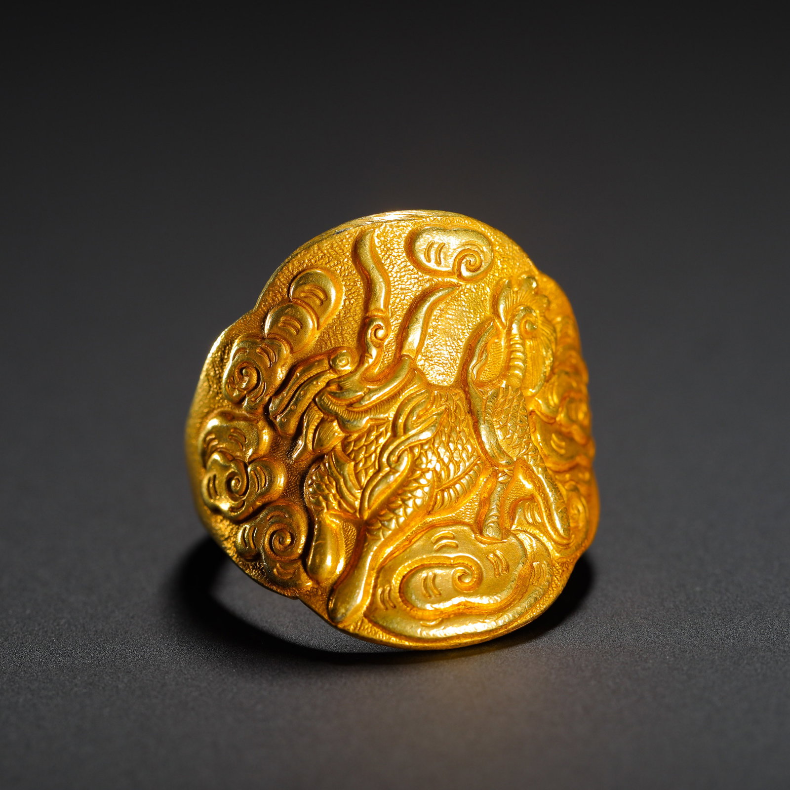 Qing Dynasty, Gilt Bronze Ring with High-Relief Kylin and Cloud Pattern: Gilt bronze ring with high-relief kylin and cloud pattern, Qing Dynasty. The ruyi-shaped face is covered with fine fish-roe ground, carved with a vivid kylin treading auspicious clouds in deep relief 
