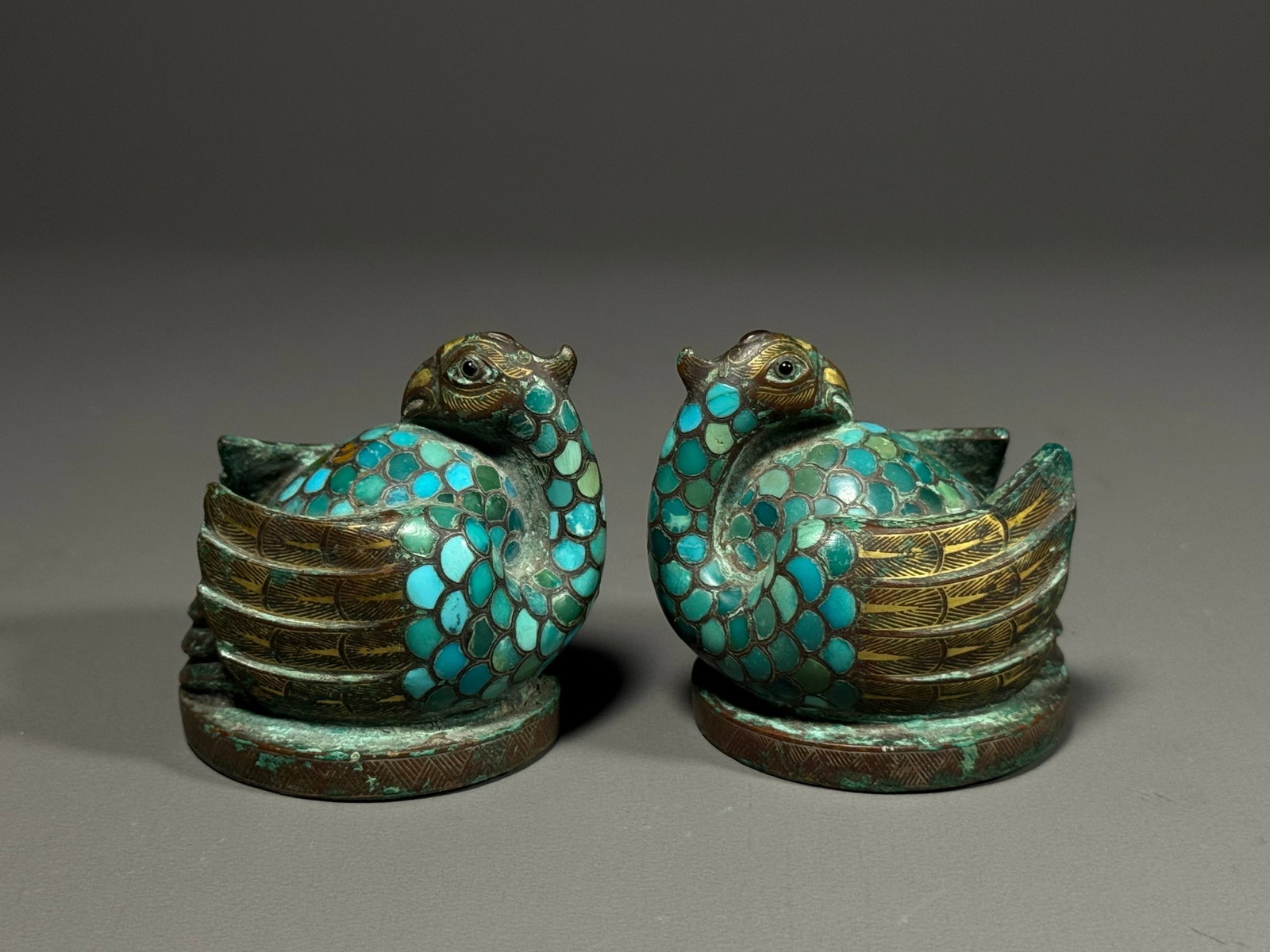 Han Dynasty, Pair of Gilt and Turquoise Inlaid Bronze Bird Weights: Han Dynasty, A Pair of Gilt-Inlaid Bronze Weight in Form of Divine Bird, Inlaid with Turquoise.Modeled as a pair of recumbent divine birds with plump bodies and folded wings turning backward. Feather 
