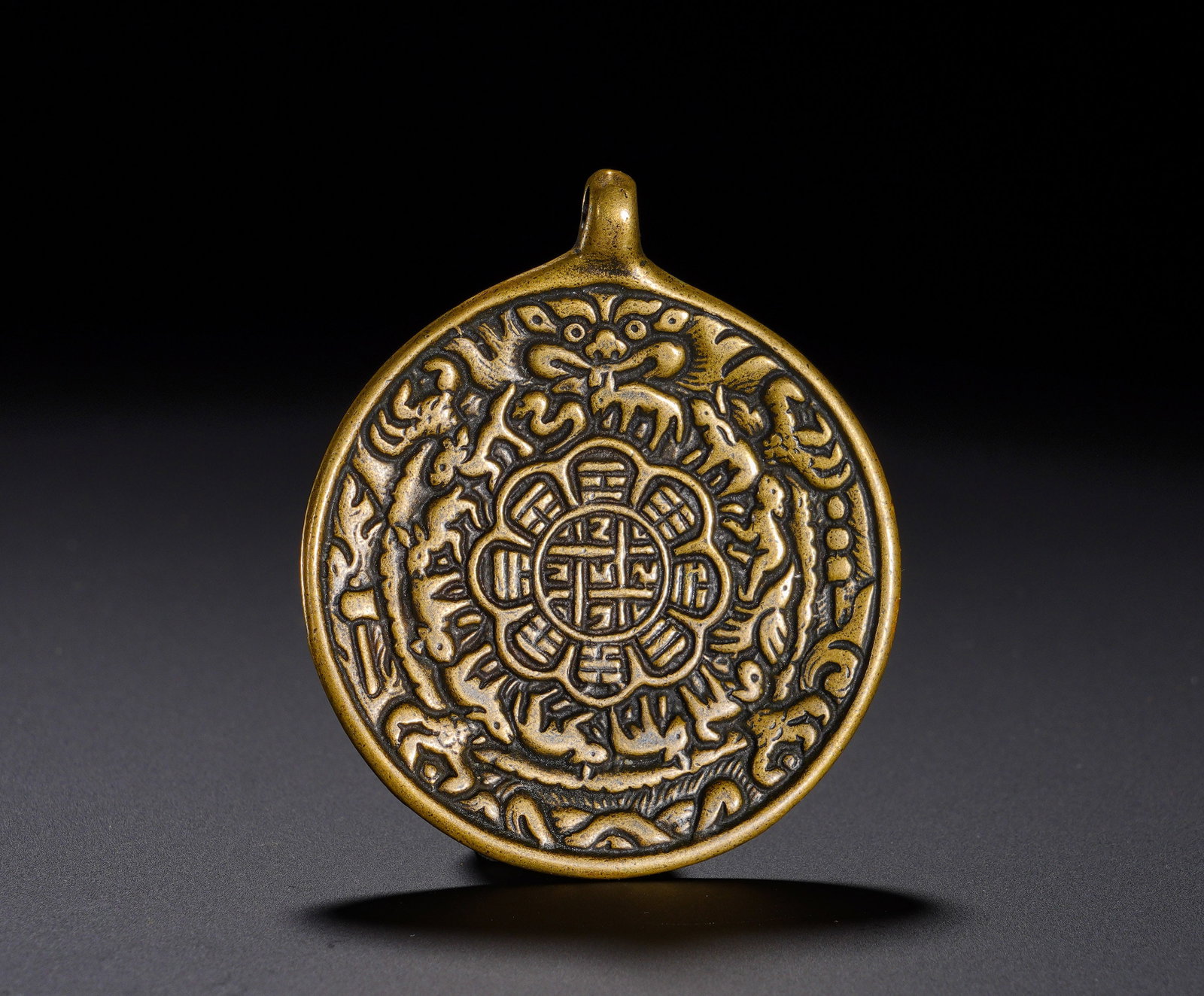 Qing Dynasty, Bronze Nine Palaces and Eight Trigrams Plaque: The Tibetan-style protective amulet of the Qing dynasty is integrally cast in brass with a suspension loop for cord mounting. Its densely-relieved surface displays central nine-palace eight-trigram