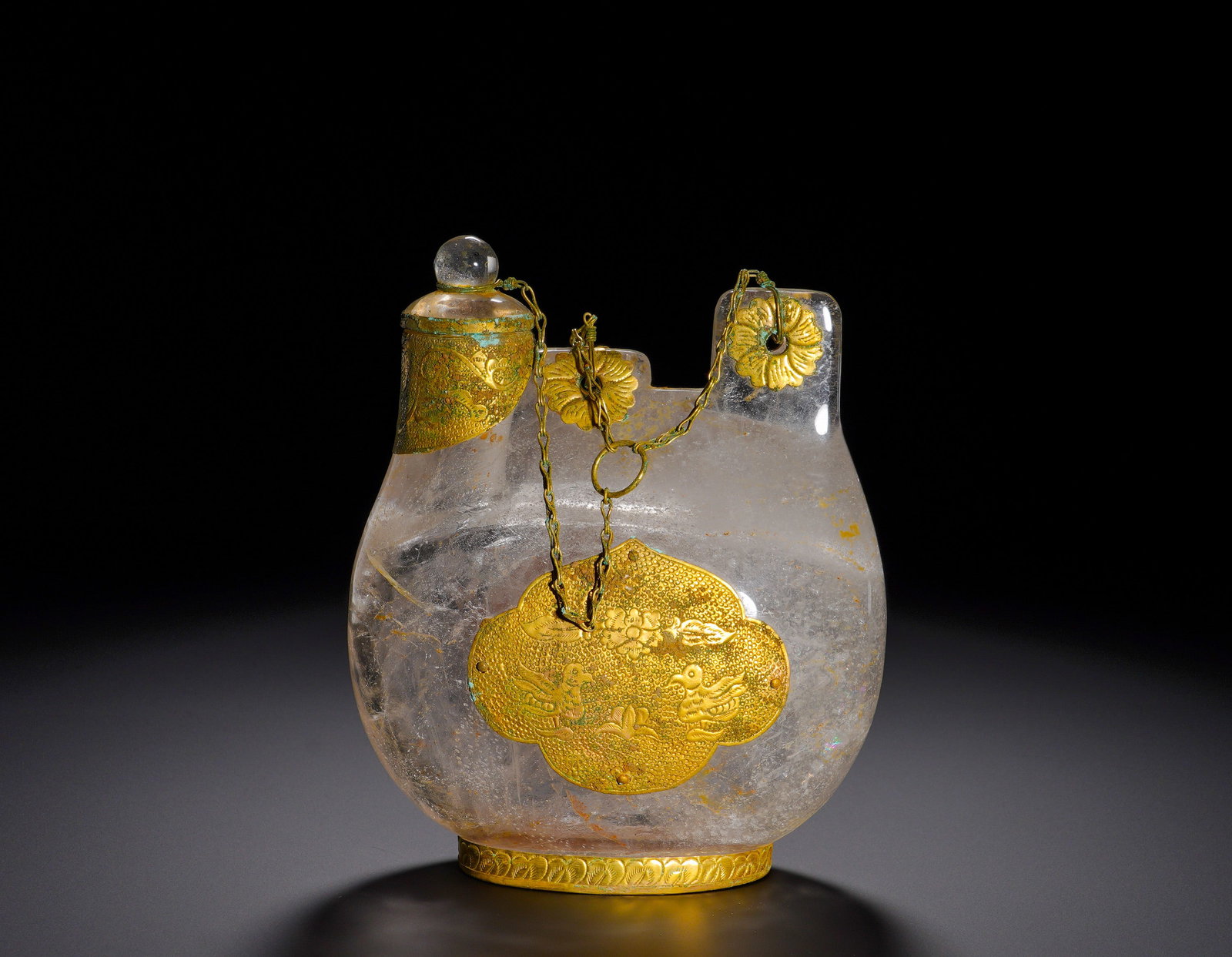 Liao Dynasty, Crystal Gilded Flower-And-Bird Patterned Leather Bag: Carved from a single block of natural rock-crystal, modeled after nomadic leather-bag ewer form, with natural inclusions and fissures within the translucent body. It is fitted with a rock-crystal knob