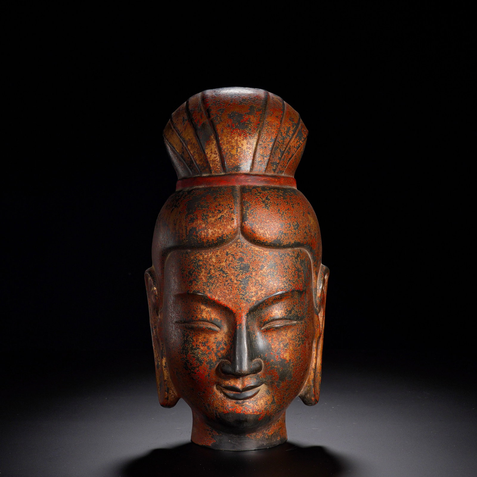 Gilded Bronze Statue of a Bodhisattva: A gilt-bronze bodhisattva head of the Qing dynasty, hollow-cast with an opening at the neck. The hair is arranged into a tall top-knot segmented into pleats, adorned with vermilion-painted headband. T