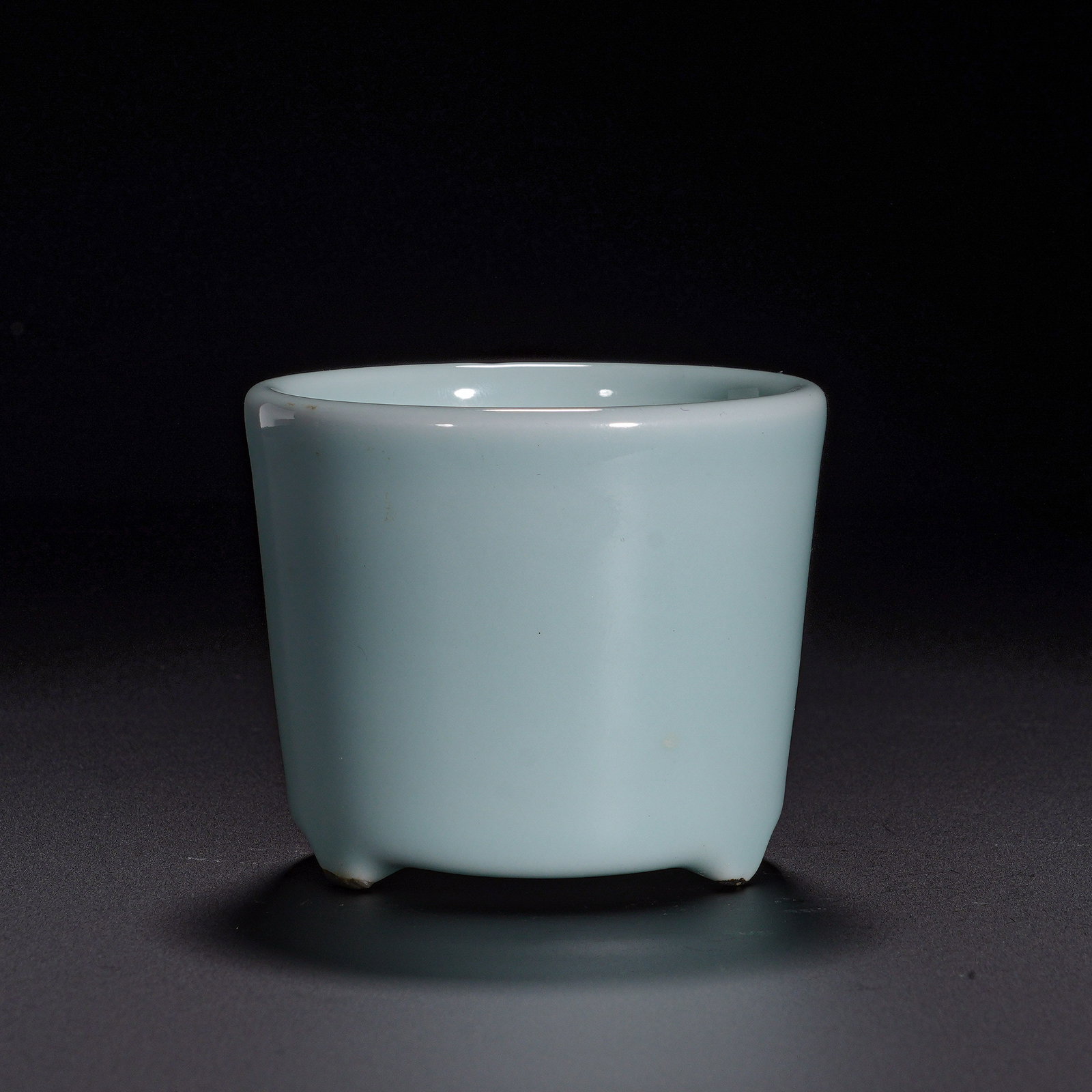 Qing Dynasty, Powder Blue Glazed Cylinder Three-Legged Stove: A scholar-studio incense burner of the Qing dynasty, Qianlong reign. It features an open mouth, straight cylindrical wall and three small bud-shaped feet with a simple, neat silhouette. The whole body
