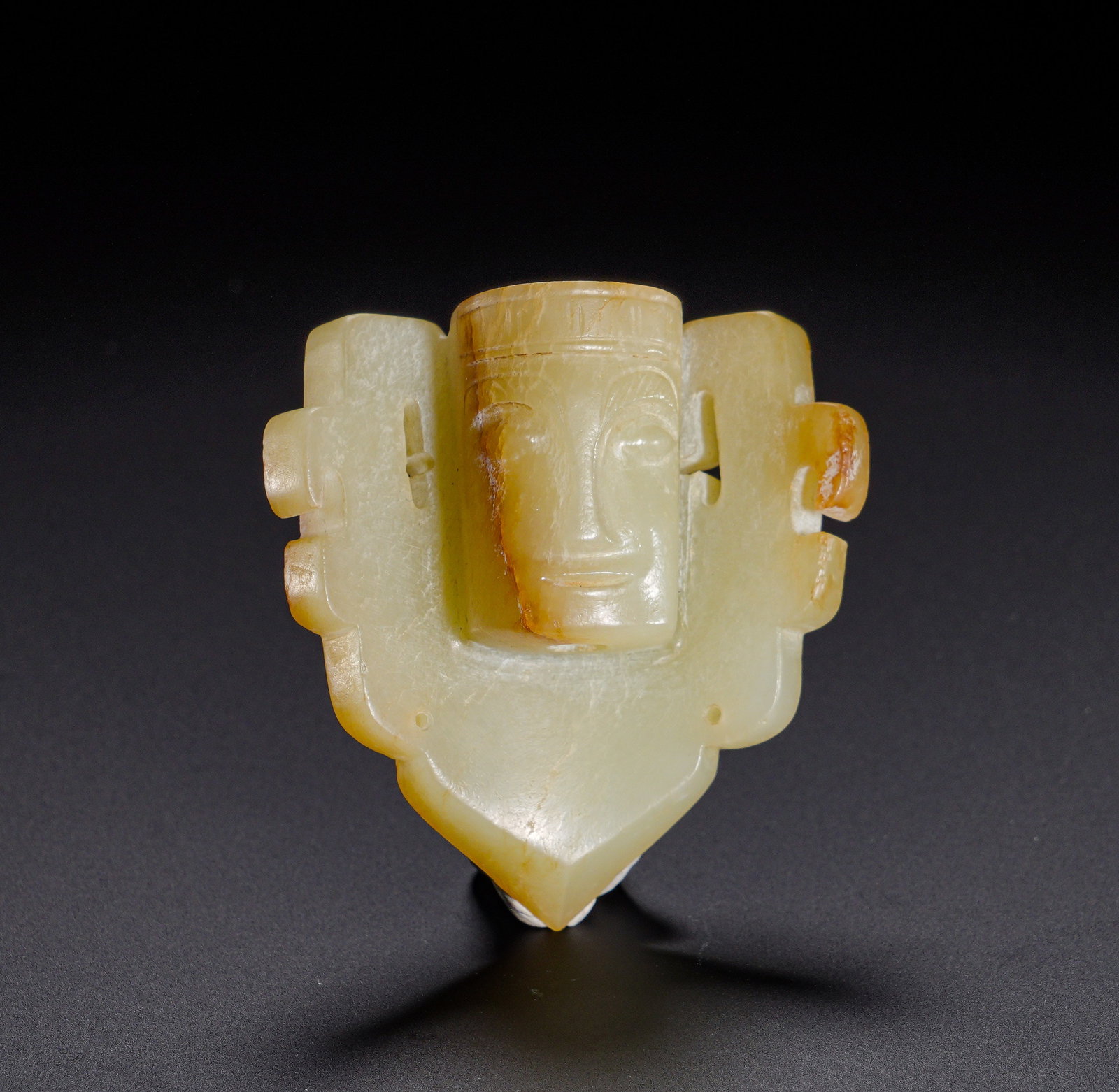 Shang and Zhou Dynasties, Hetian Jade Divine Human Head Appears Halberd Pendant: Carved from Hetian jade, this pendant has mild texture suffused with pale-yellow patina in partial deeper tones, covered by restrained antique patina. It adopts composite structure with a central circ