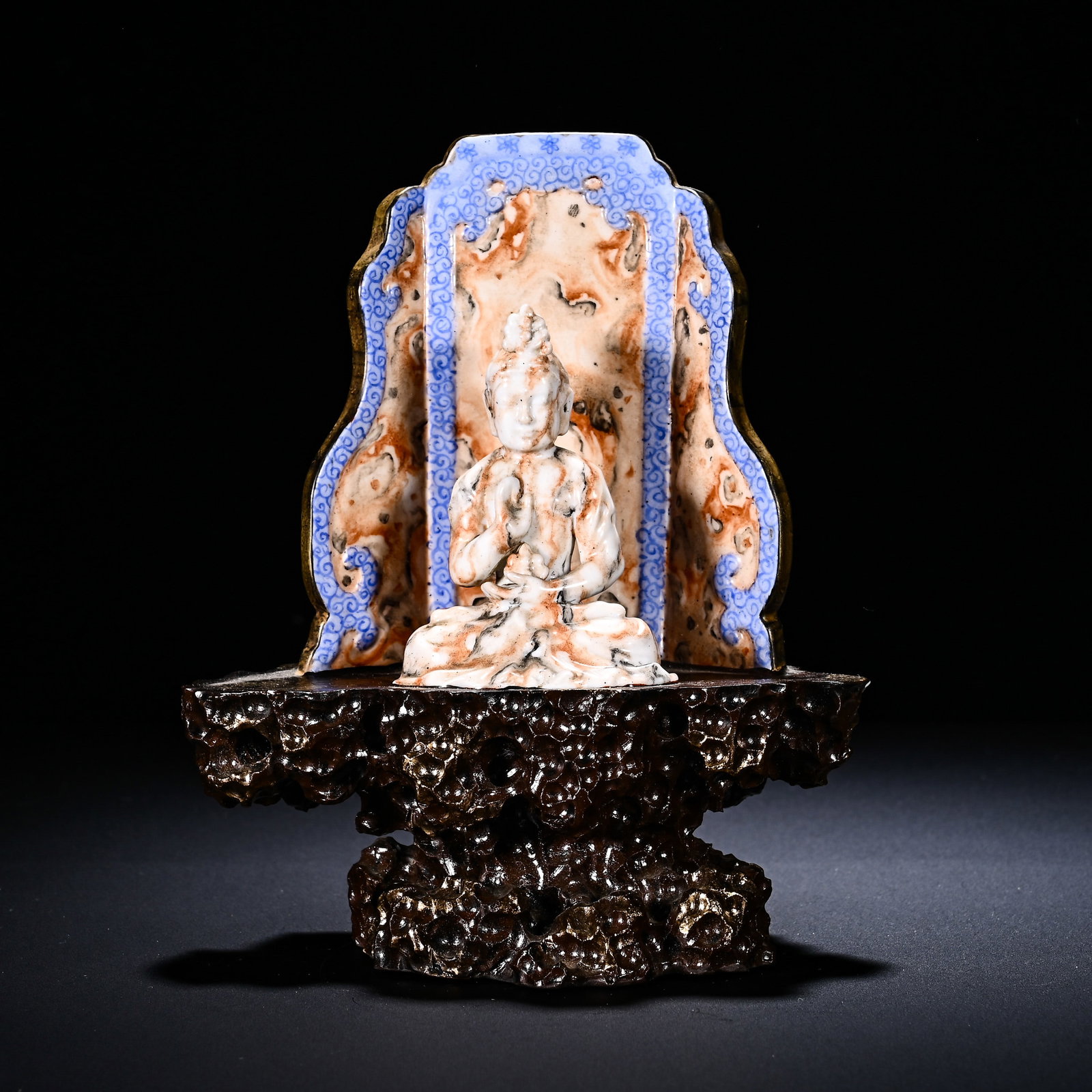 Qing Dynasty, Qianlong Stone-Patterned Glazed Porcelain Buddha Statue: A Qianlong-period porcelain Buddha statue with stone-imitation glaze, assembled from three parts: figure, stone-pattern back-screen and root-shaped porcelain base. The Buddha sits in full-lotus positi