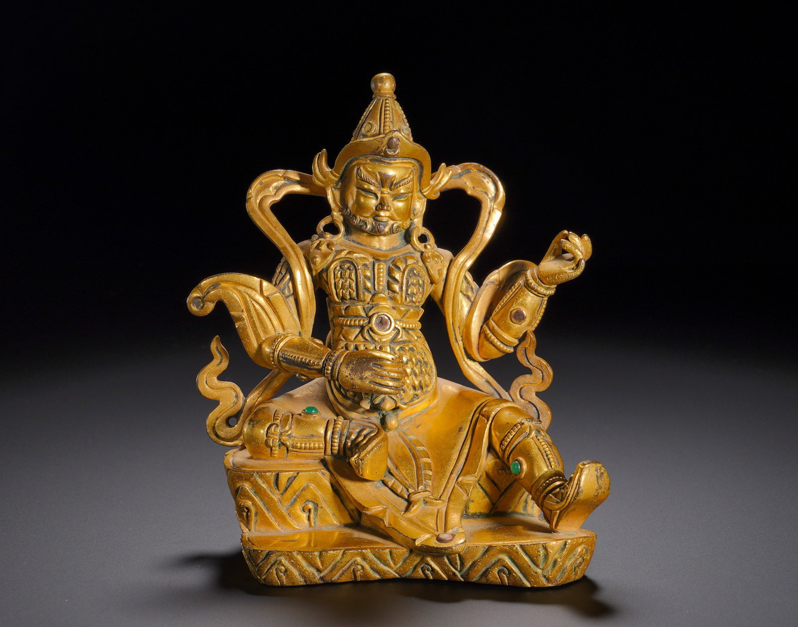 Qing Dynasty, Gilded Bronze Seated Statue of the Yellow God of Wealth: Gilt Bronze Seated Statue of Yellow JambhalaThis gilt bronze statue of Yellow Jambhala sits in the relaxed lalitasana posture upon a mountain-shaped pedestal. He bears a dignified facial expression wi