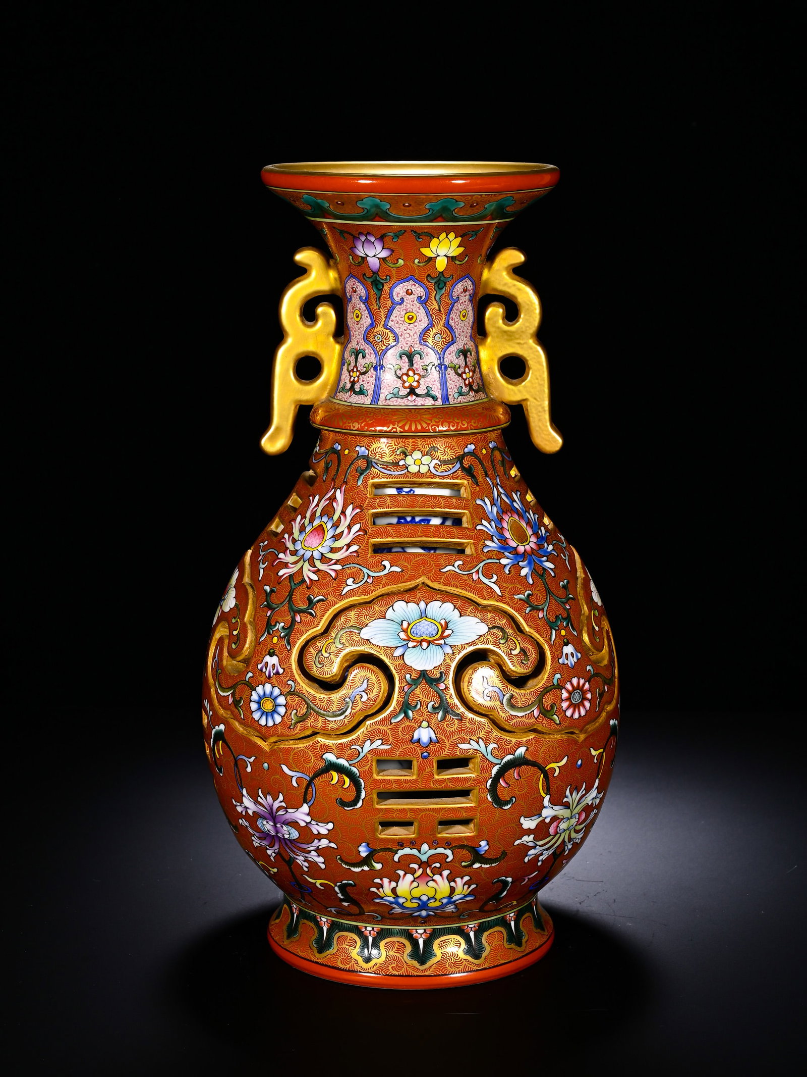 Qing Dynasty, Qianlong Pastel Flower Octagonal Hollowed-Out Revolving Heart Vase: A Qianlong-period revolving vase with iron-red ground, incised brocade pattern, famille-rose scrolling flowers and eight-trigram openwork. Flared mouth, slender neck with gilded kui-dragon handles. Ir