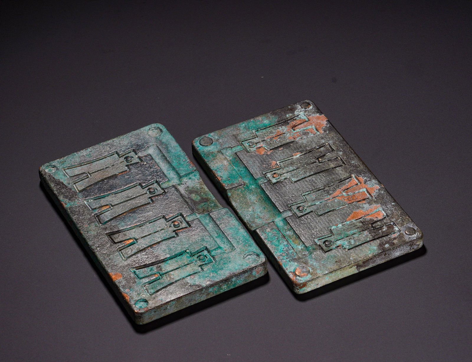 Warring States Period, Bronze Square-Footed Coin Molds: A matched pair of bronze casting molds for square-foot spade coins of the Warring States Period. The two rectangular bronze plates are carved with four cavities for spade coins each, with circular pos