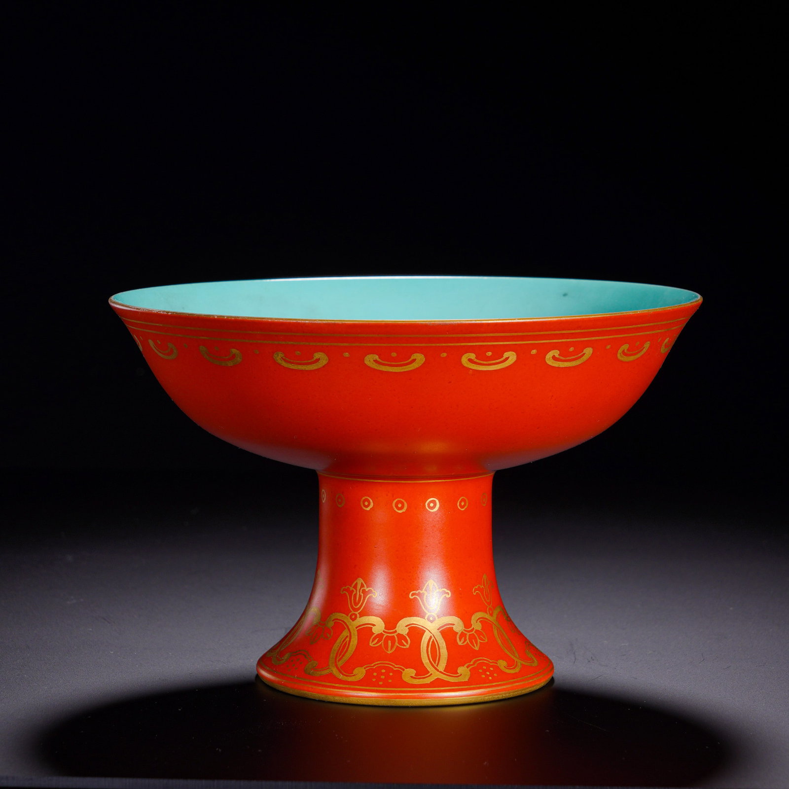 High Foot Offering Plate with Coral Red Ground, Gilded Entwined Floral Branches: An imperial Buddhist altar vessel, with wide flared rim, shallow bowl and tall flaring stem. The exterior is entirely covered in bright even coral-red glaze, rim and foot edge gilded, interior fully g