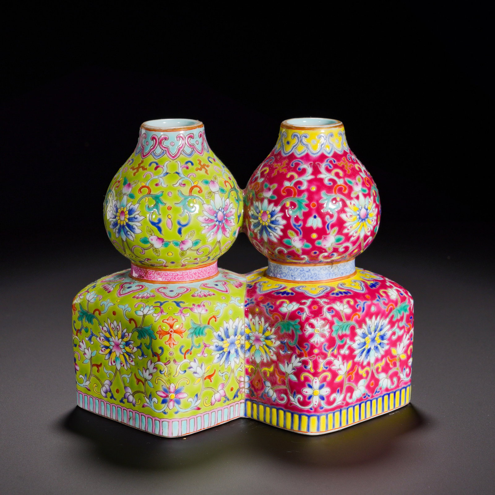 Qing Dynasty, Double Gourd-Shaped Vase of the Qianlong Period: Uniquely-shaped conjoined double vase. Each upper section is gourd-form, joined to a rhombus-shaped integrated base. One vase has lime-green ground, the other rose-crimson ground, both densely painted