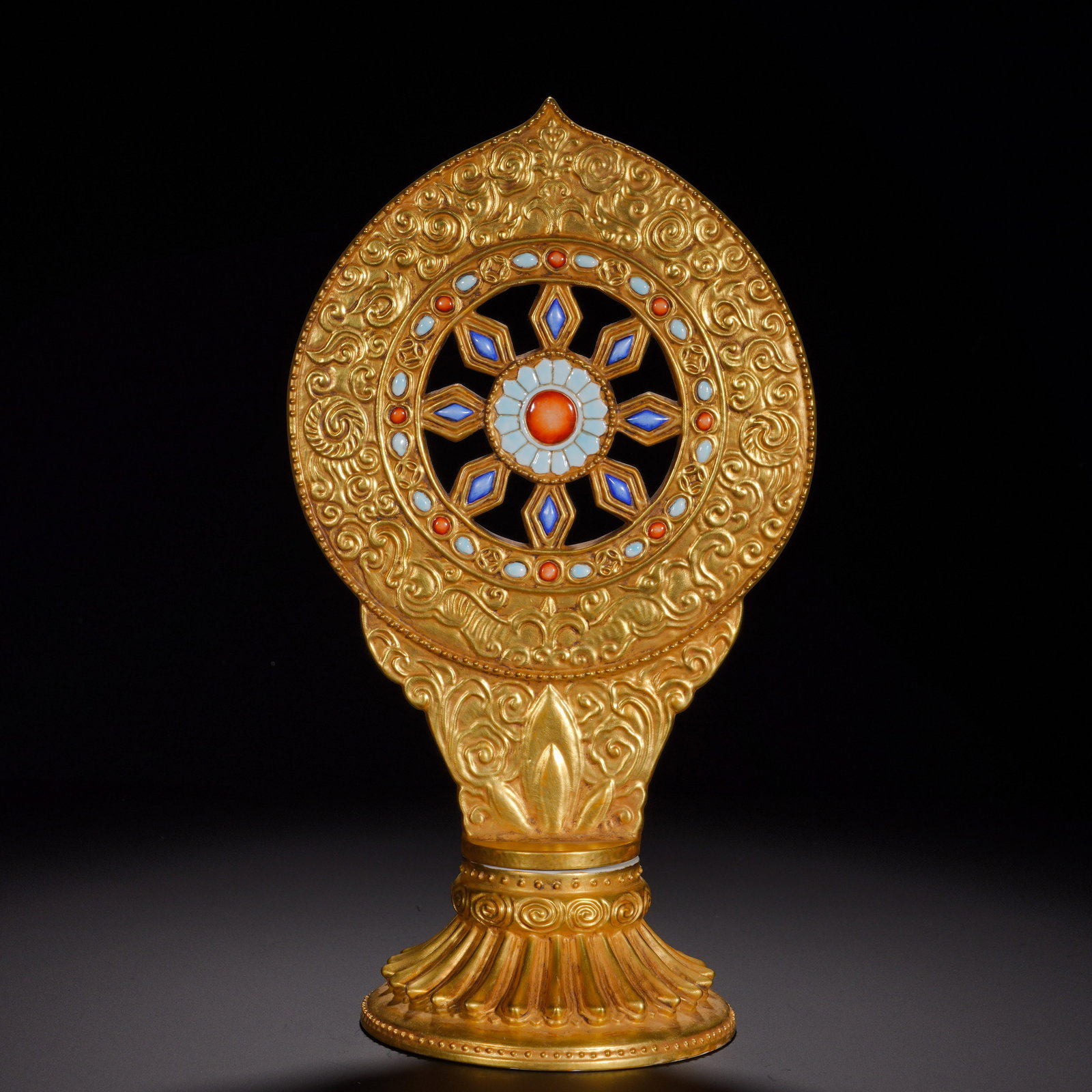 Qing Dynasty, Qianlong Period, Bronze Gilded and Inlaid Dharma Wheel Offering Vessel: A Dharma-wheel, one of the Eight Auspicious Symbols in Tibetan Buddhism. The whole bronze body is heavily gilded. The open-work wheel is richly chased with scrolling cloud-and-foliage patterns, its
