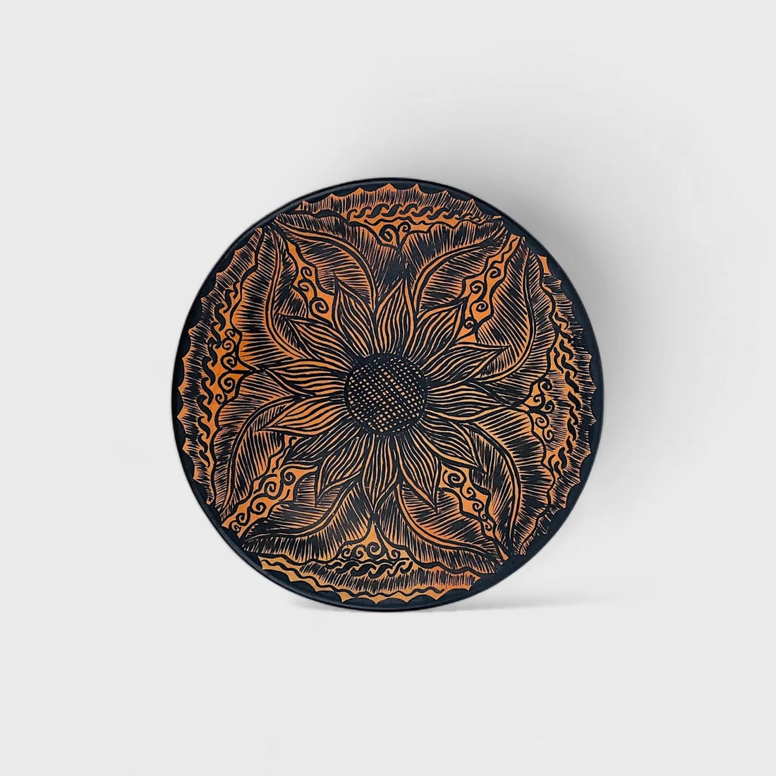 "Sun Bloom" Terracotta Plate: Albertina Lopez RamirezSun Bloom Plate0.75" (h) x 8.5" (l)1.2 lbs. Hand-etched clay with floral motif in black and terracotta.A radiant celebration of nature and form, Sun Bloom Plate by Albertina