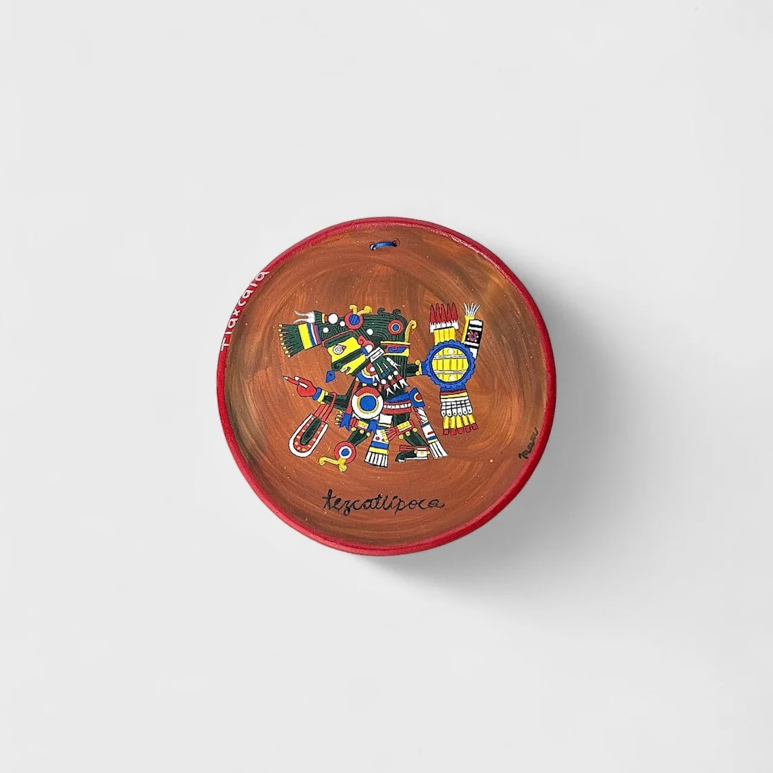 "Tezcatlipoca Tribute" Hand-crafted Ceramic Plate: Mace Tezcatlipoca Tribute Plate10" (l)Weight not Specified. Hand-painted cermaic plate with pre-Hispanic imagery.A powerful homage to ancestral heritage, Tezcatlipoca Tribute Plate by Mace features a