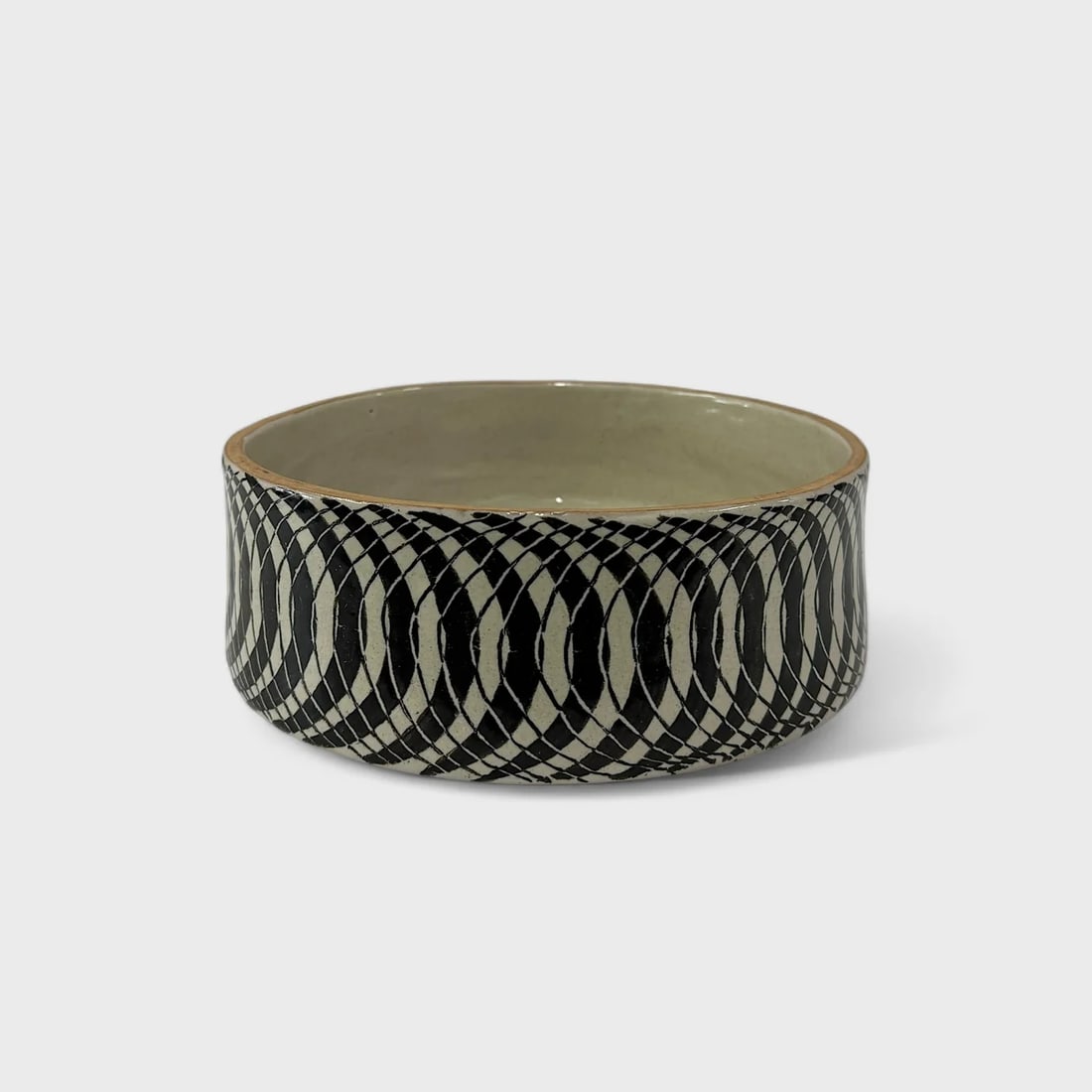 "Hypnotic Vortex" Hand-thrown and Painted Ceramic Bowl: Talavera de la ReynaHypnotic Vortex Bowl3.5" (h) x 10" (l) x 10" (w)3.8 lbs. Hand-thrown and hand-painted ceramic. Black and white geometric motif. Mesmerizing in its detail and precision, the