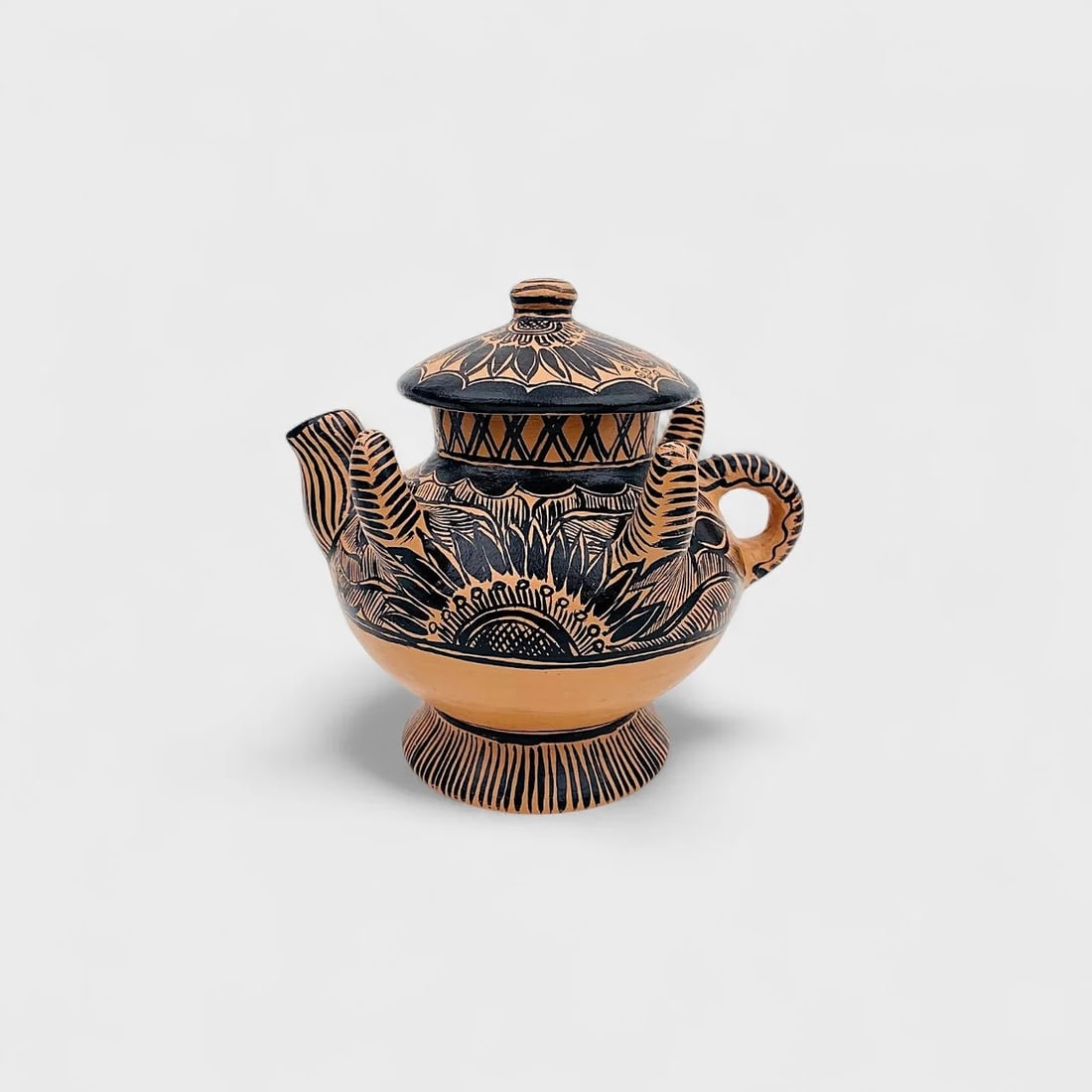 "Sunburst Jaguar" Natural Clay Teapot: Albertina Lopez RamirezSunburst Jaguar Teapot7" (h) x 7" (l) x 6.5" (w)2 lbs. Hand-sculpterd clay with etched jaguar and botanical motifs, black slip finish. Blending ceremonial symbolism with everyda