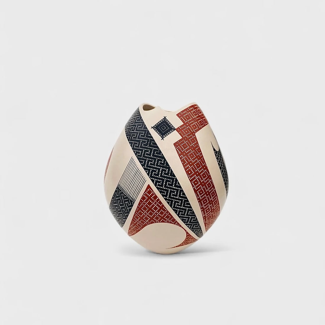"Precision in Miniature" Hand-coiled Ceramic Vase: Elias PeñaPrecision in Miniature7" (h) x 6" (l)0.5 lbs. Hand-coiled and painted ceramic, black and terracotta geometric pattern. Signed. Small in size but monumental in craftsmanship, Precision in Mi