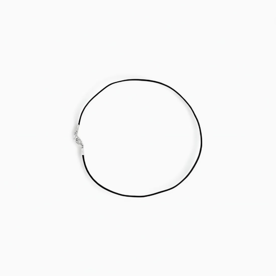 "Linea Negra: The Minimalist Silver" Necklace: Understated yet deliberate, Linea Negra distills Sergio Bustamante’s artistic voice into its most essential form. This unembellished rubber cord necklace is punctuated with handcrafted .925