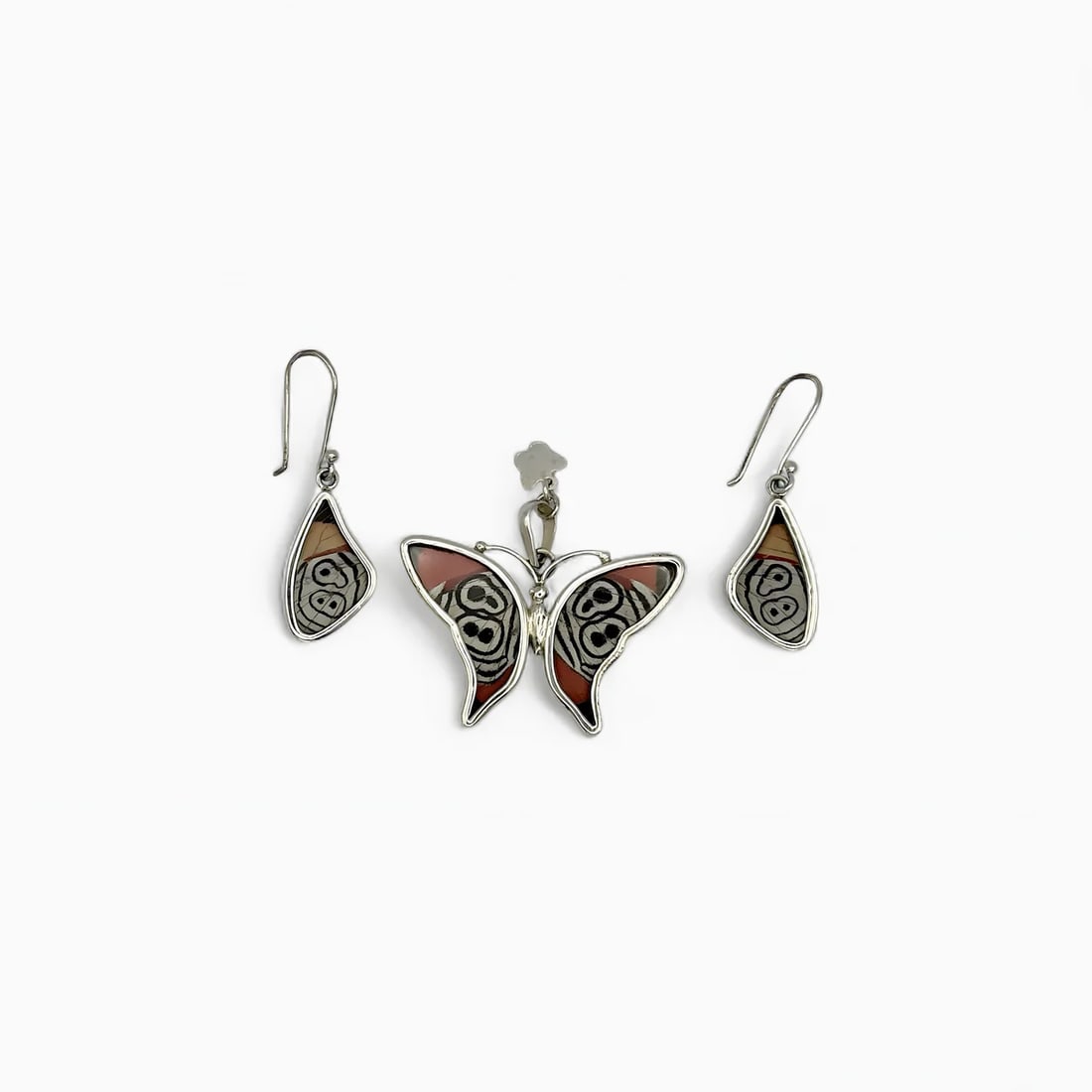 "Eclipse Eye" Pendant & Earring Jewelry Set: The Eclipse Eye Pendant & Earring Set by Yolanda Ormachea captures the mystery and contrast of nature’s design with its rich, dual-sided detail. This handcrafted set features a butterfly-shaped