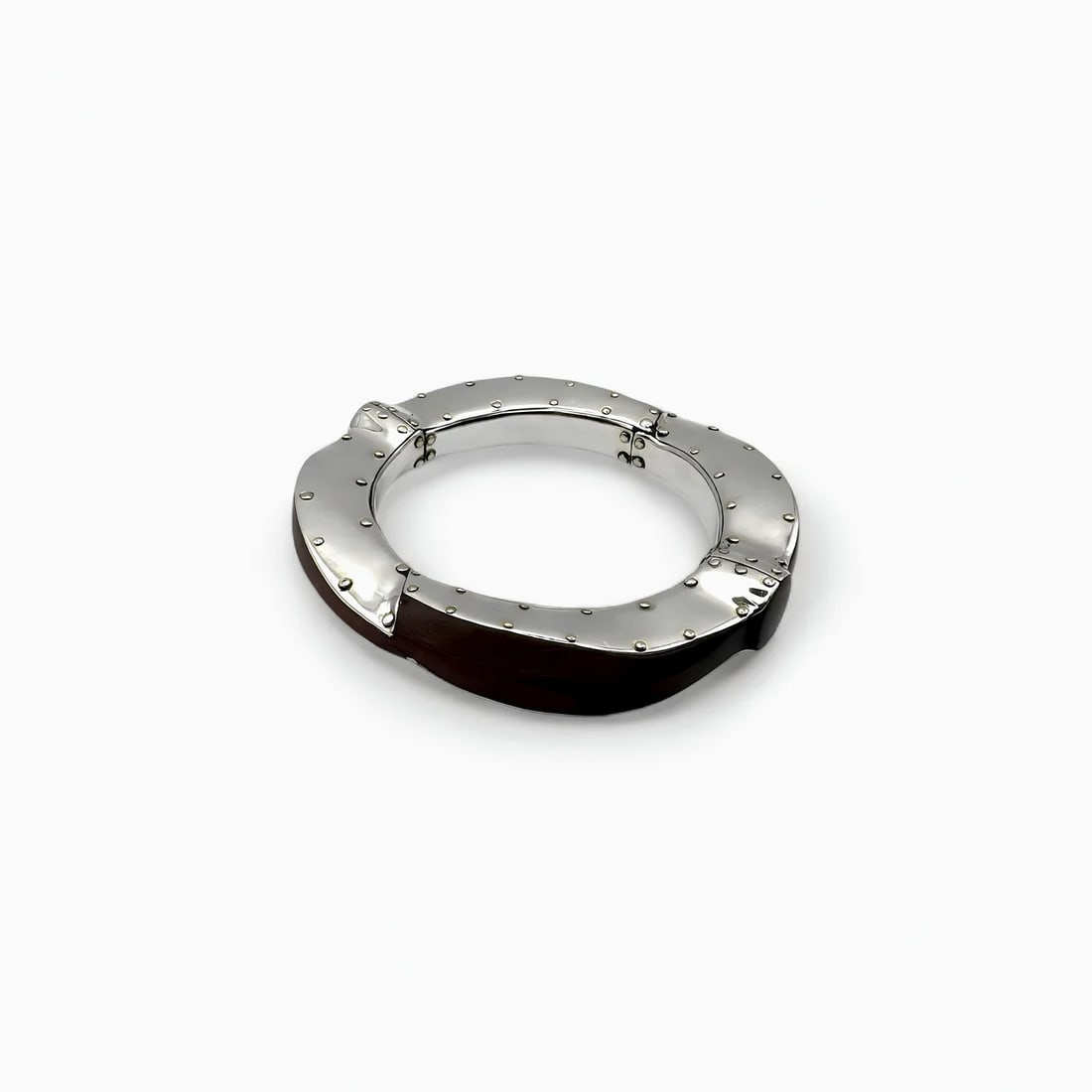 Silver and Polished Wood Bracelet: Blending the elegance of silver with the warmth of natural wood, this statement bracelet by Carmen Tapia showcases the harmony of contrast in artisan jewelry. The bold, circular structure is crafted f