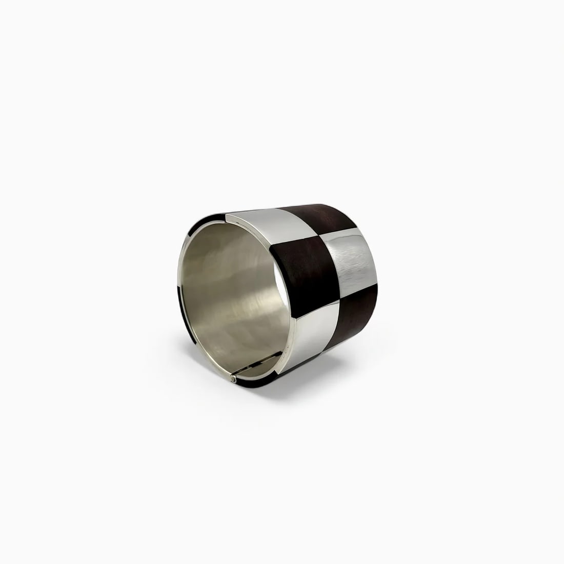 “Shadow Grid?? Silver and Wood Bracelet: Blending bold contrast with minimalist elegance, the “Shadow Grid” bracelet by Carmen Tapia showcases a seamless union of dark-stained wood and polished sterling silver. Each rectangular panel