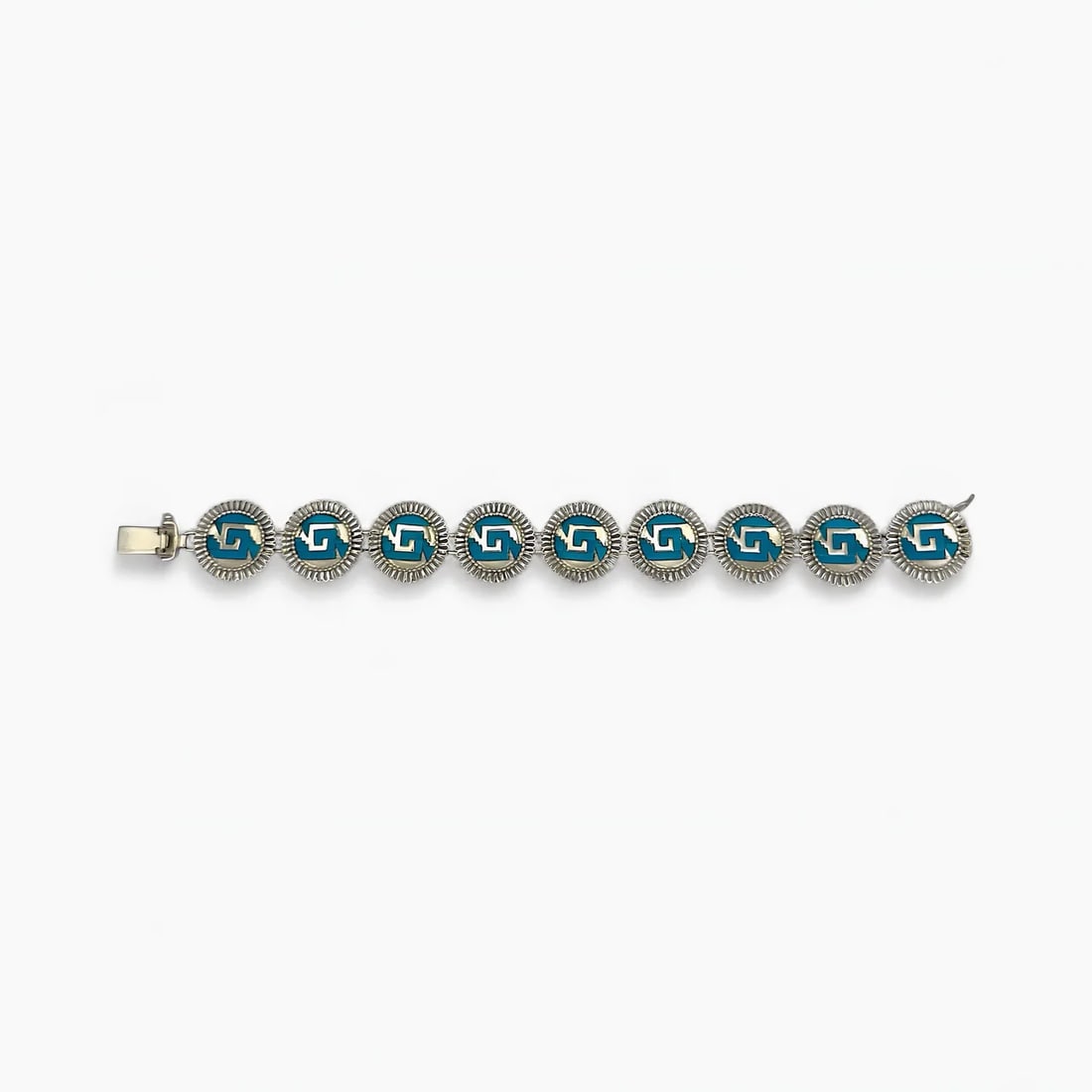 "Shield Link" Turquoise Bracelet: The Turquoise Shield Link Bracelet by Oro de Monte Albán brings together tradition and symmetry through a series of handcrafted medallions. Each circular link features a stylized chimalli—the Aztec