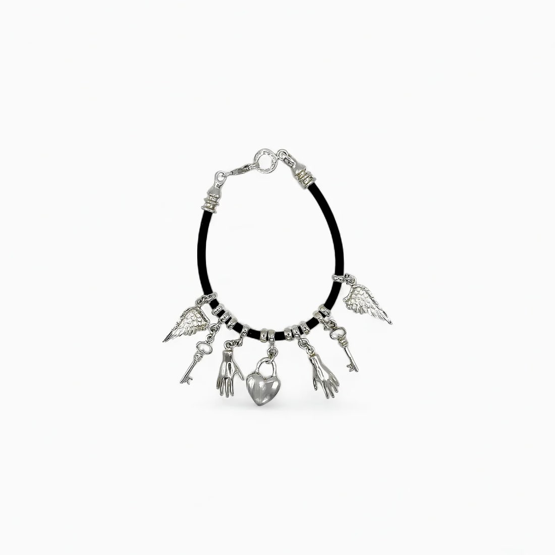 "The Oracle’s Pact: Delfos" Silver Charm Bracelet: Mystical and richly symbolic, The Oracle’s Pact conjures visions of ancient wisdom and modern alchemy. Dangling from a sleek black rubber cord, each handcrafted silver charm—wings, hands, hearts, 