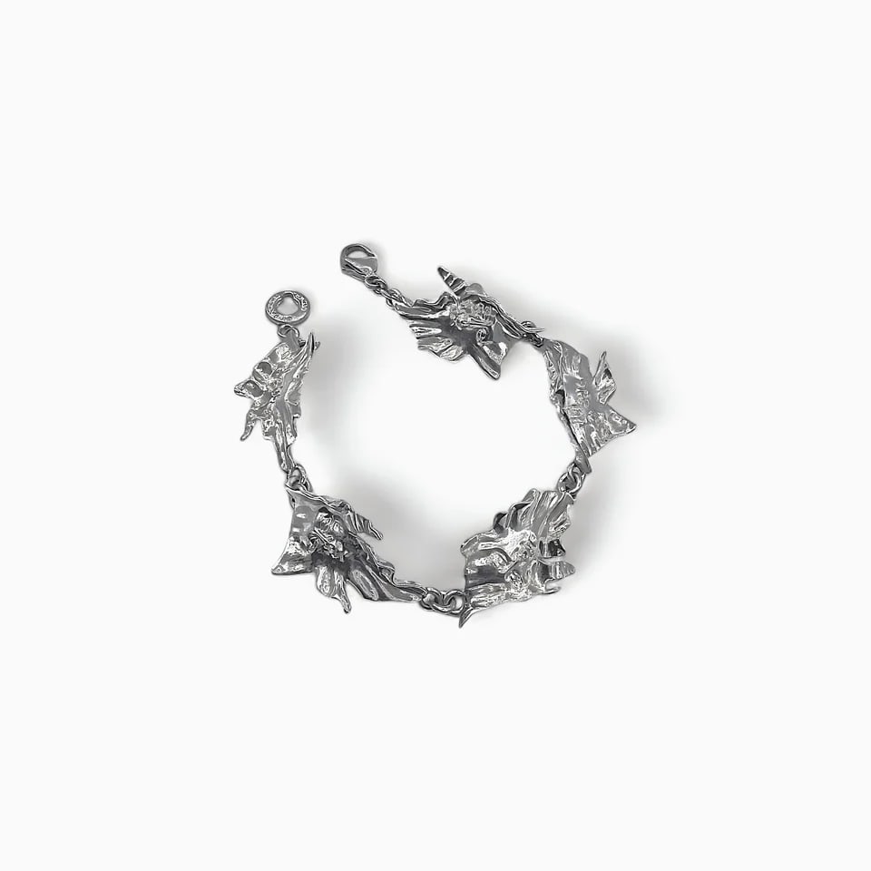 "Veil of Echoes: The Mantle" SIlver Bracelet: Flowing like wind over stone, Veil of Echoes is a study in movement and form. This striking bracelet is composed of interlocking silver panels, each sculpted in Bustamante’s signature surrealist sty