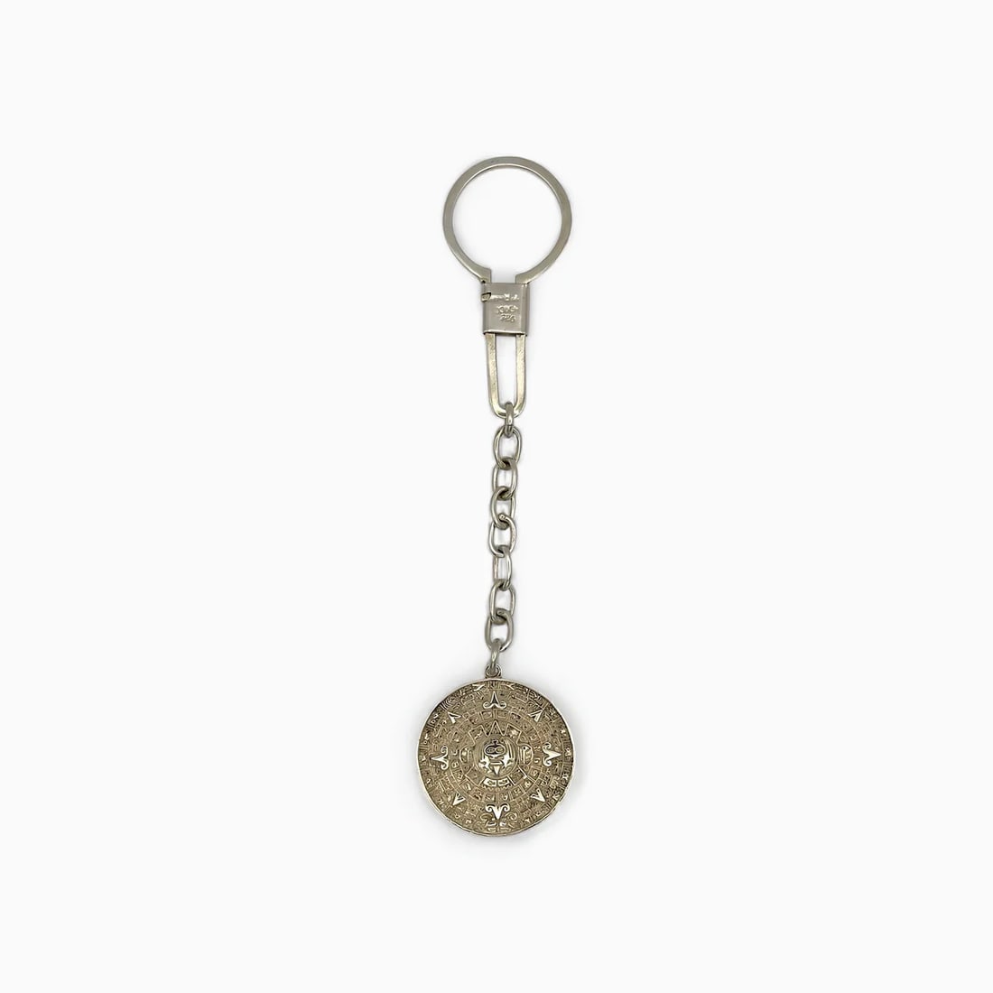 "Aztec Calendar l" Keychain: A symbol of ancient precision and cosmic order, the Aztec Calendar Keychain by Oro de Monte Albán brings the grandeur of Mesoamerican timekeeping to your everyday essentials. Cast in sterling silver,