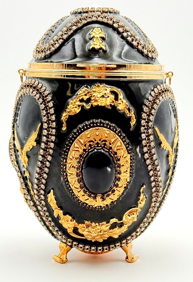 Vivian Alexander "Black Gold" Enameled Egg: Handcrafted in 1998 | Original Retail: $2,100. A timeless custom piece from the Vivian Alexander Vintage Collection. Jet black enamel shimmers with gold mica. Black onyx-set filigreed lockets hold rom