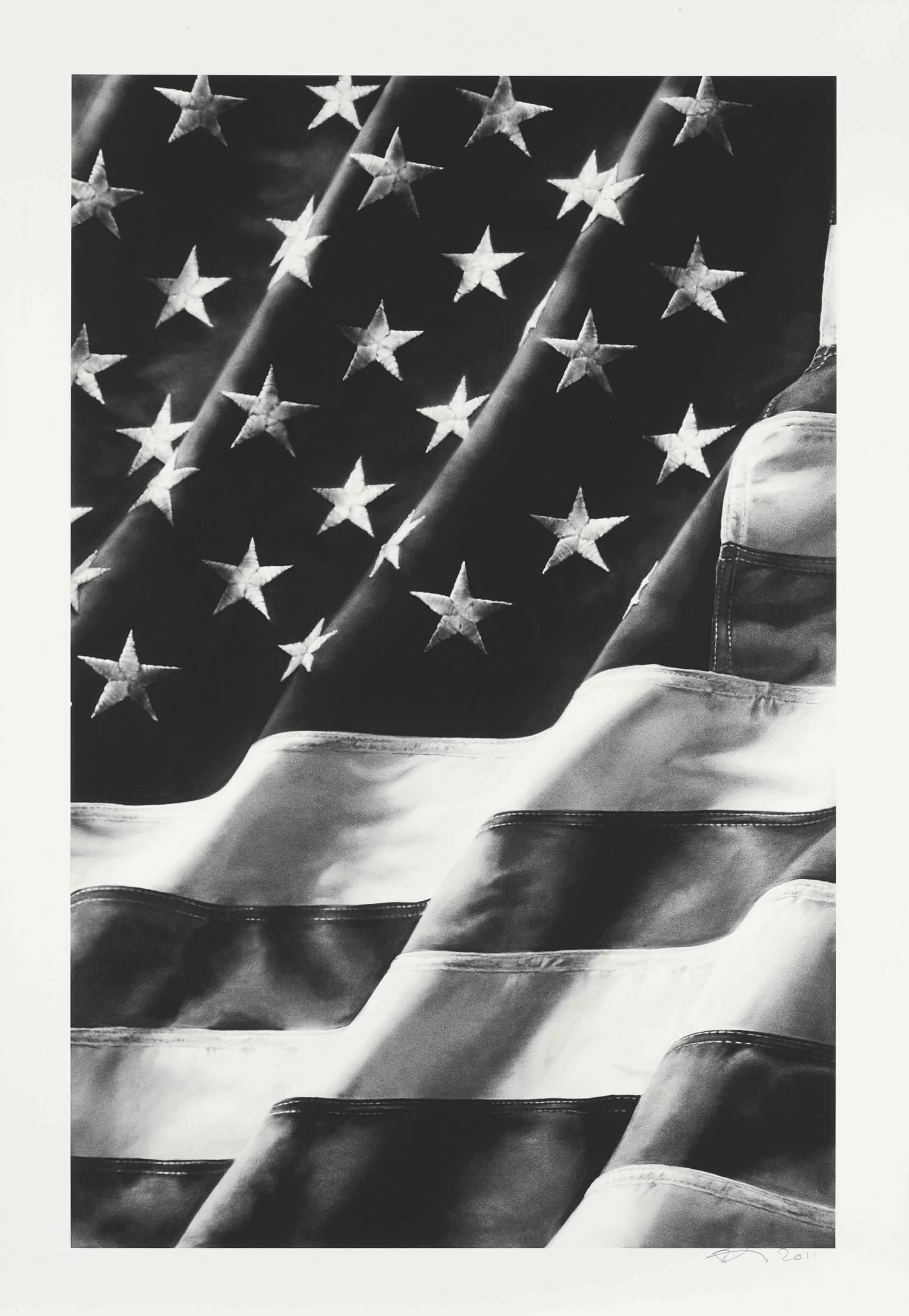 ROBERT LONGO Old Glory, Left Side, print in colors after: Measures 34 x 23 1/2 inches, print in colors on woven paper, Robert Longo is known for large-scale, hyperrealistic charcoal portraits that consider power, authority, and social unrest. In the early 19